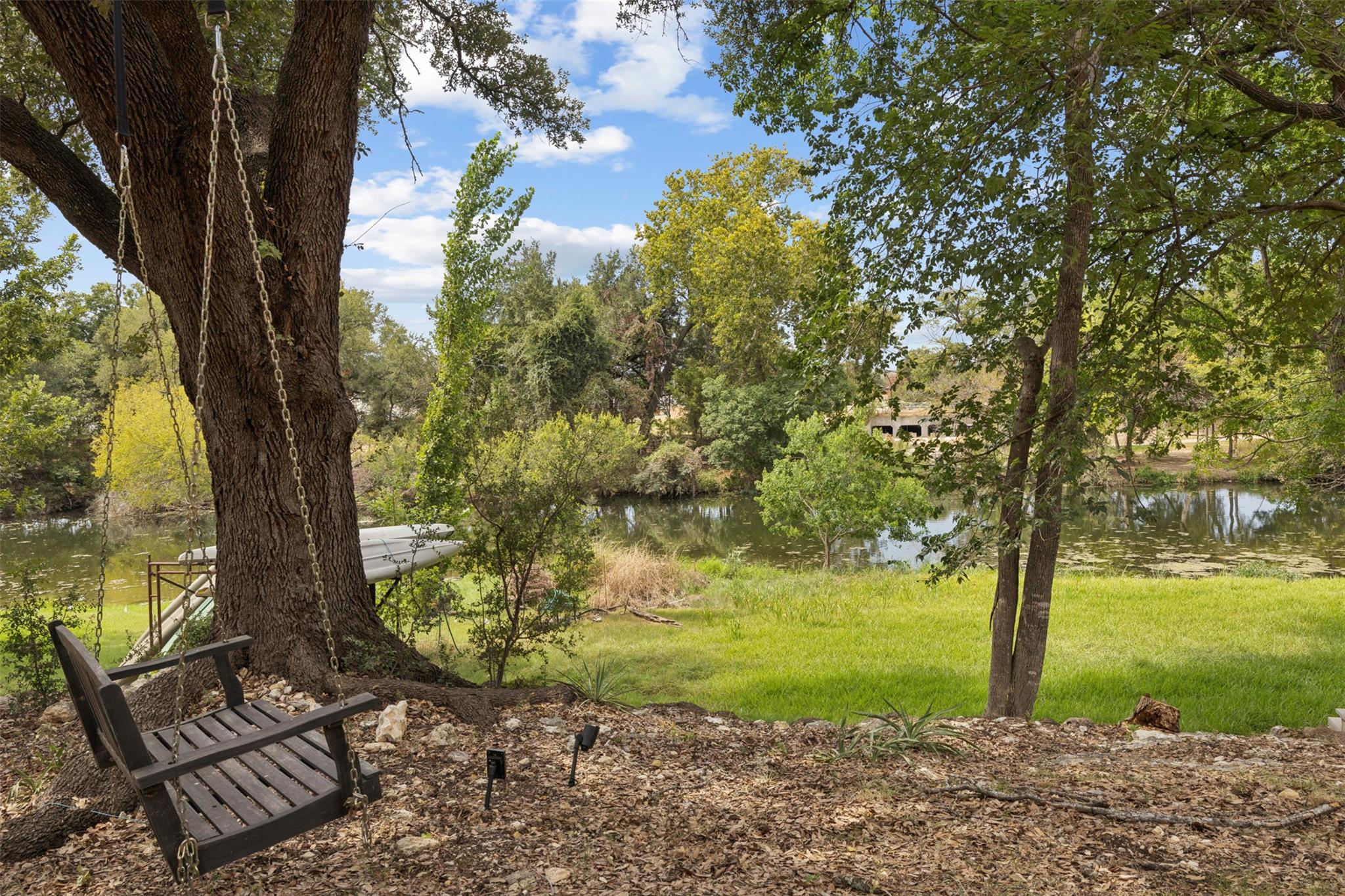 Mature trees frame a quiet river view from the gr