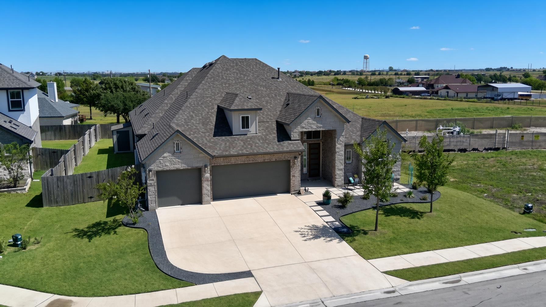 An expansive concrete driveway leads to a modern 