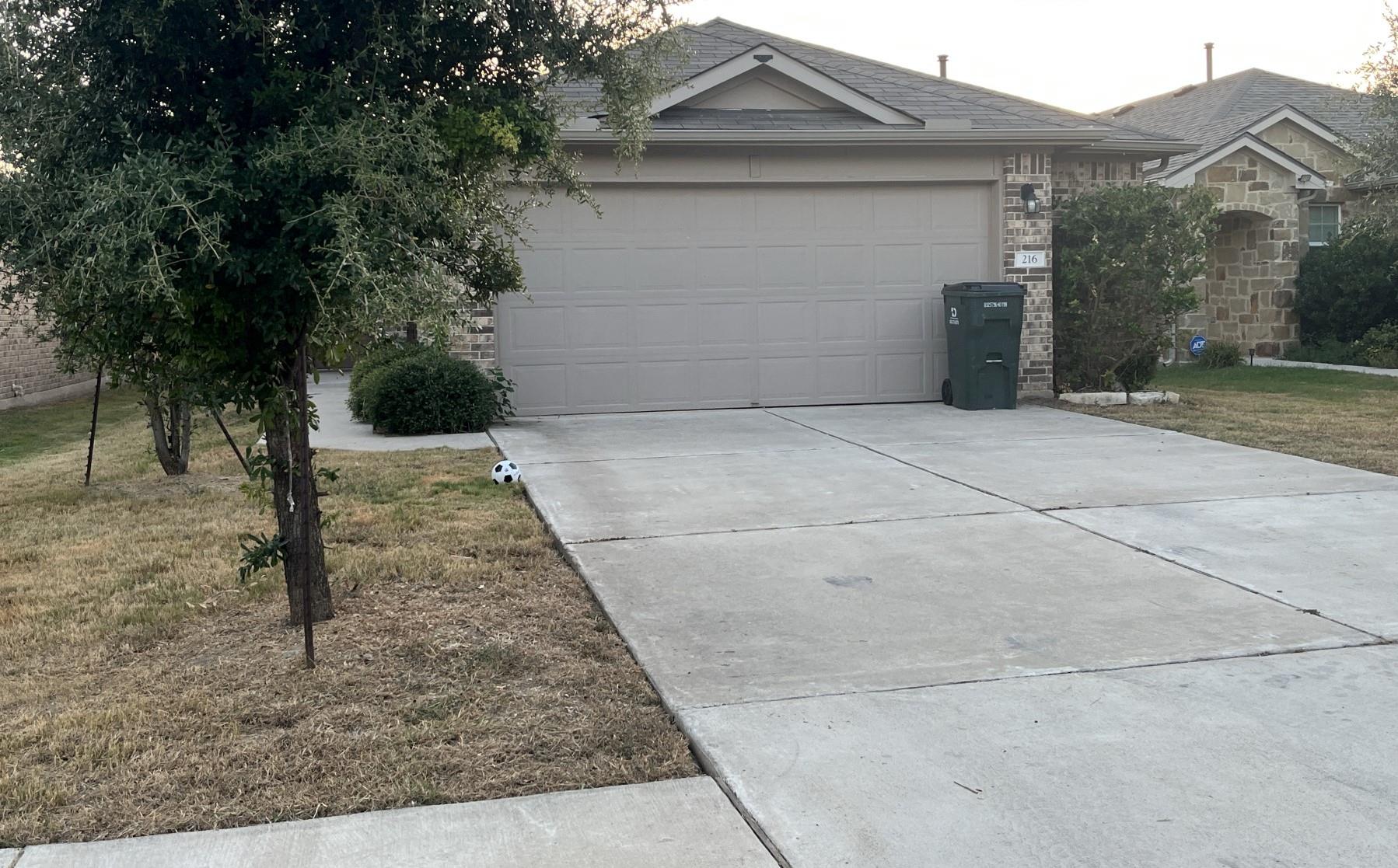A spacious concrete driveway leads to an attached