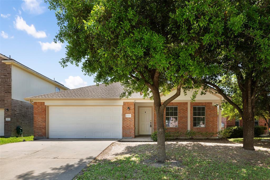 Mature shade trees frame the classic brick facade