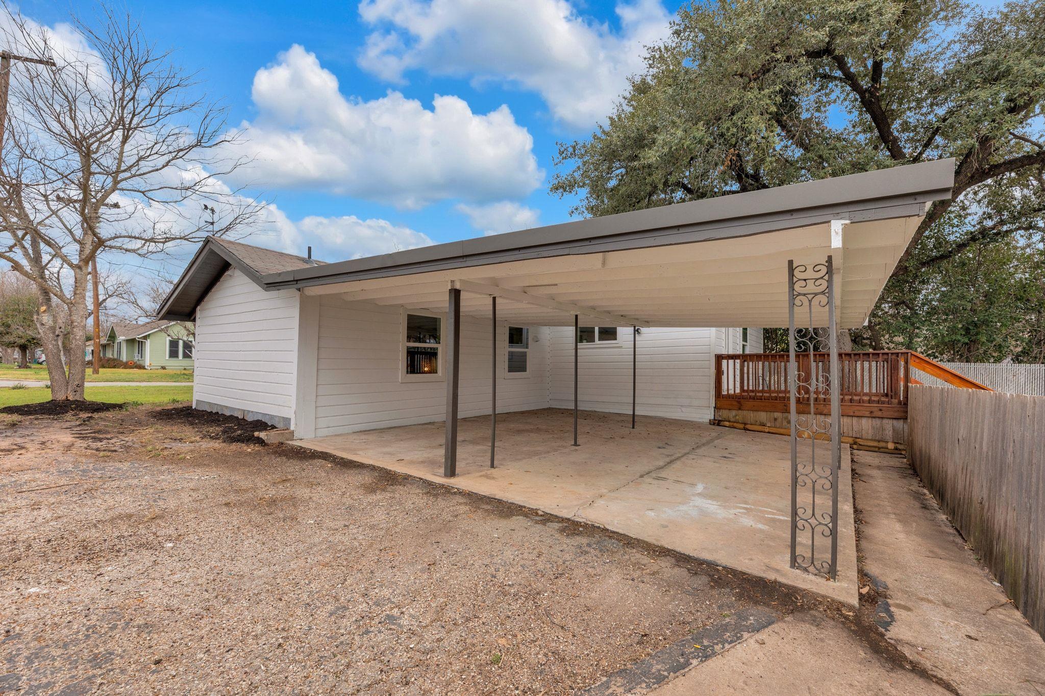 A spacious covered carport and concrete parking p