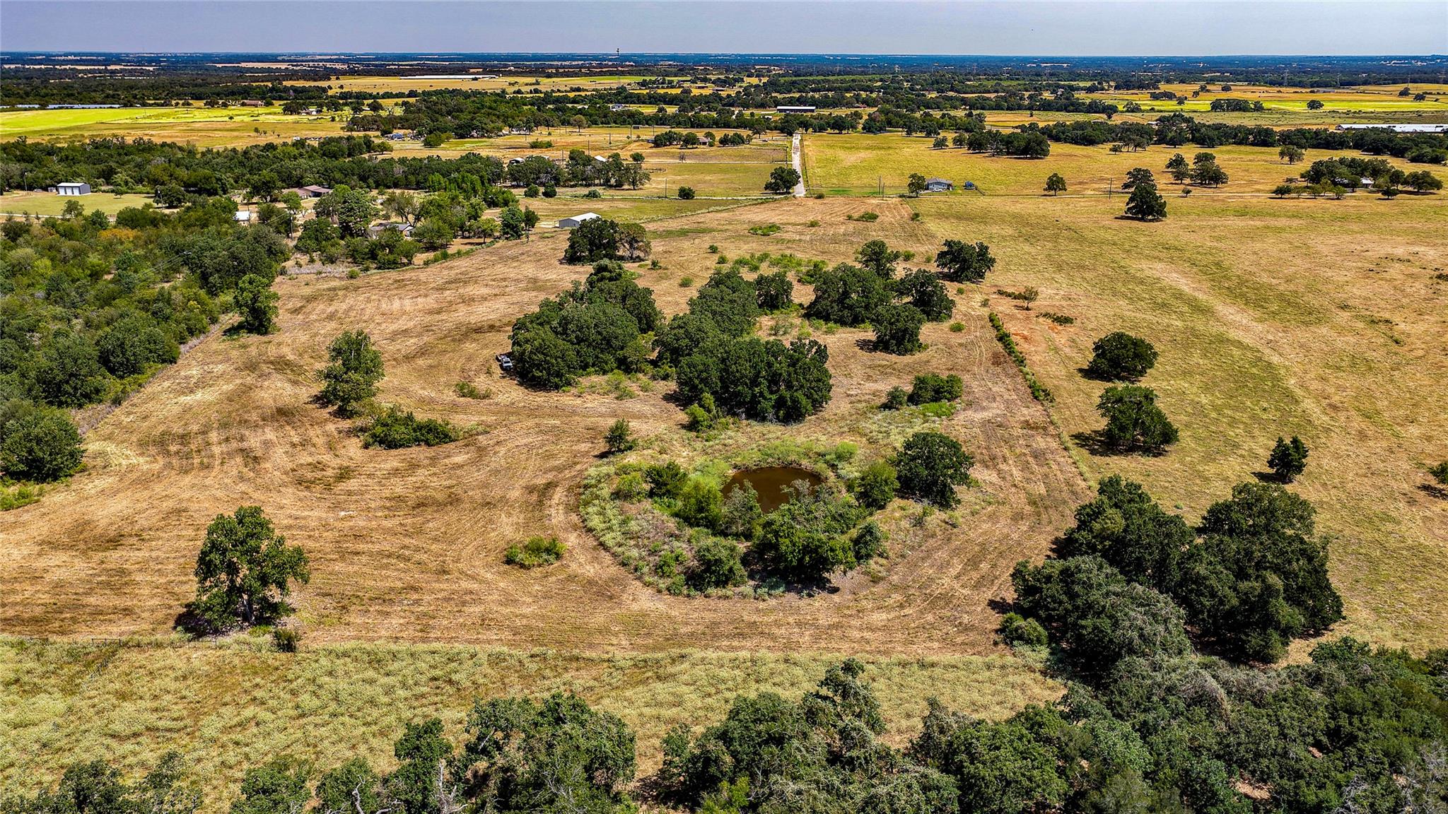 Rolling pastures and mature trees surround a smal