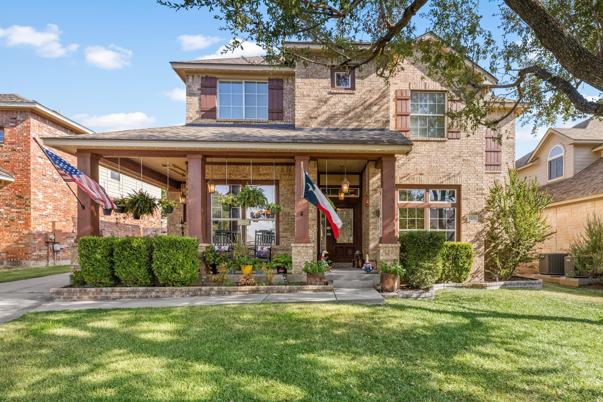 A welcoming front porch enhances the classic bric