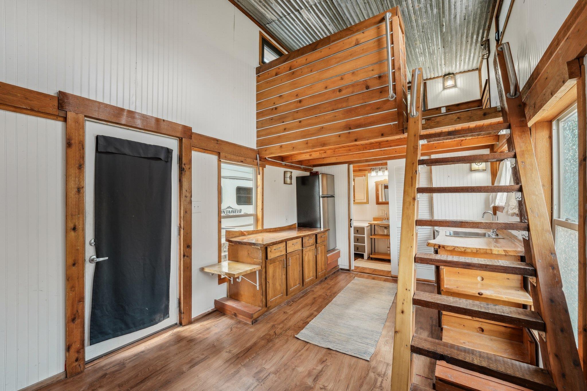 Staircase featuring wood finished floors and a to