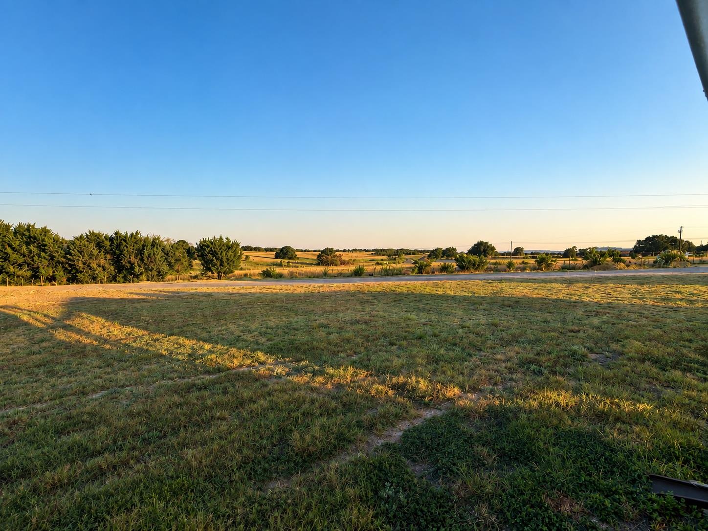 Rolling grassy fields stretch out toward a quiet 