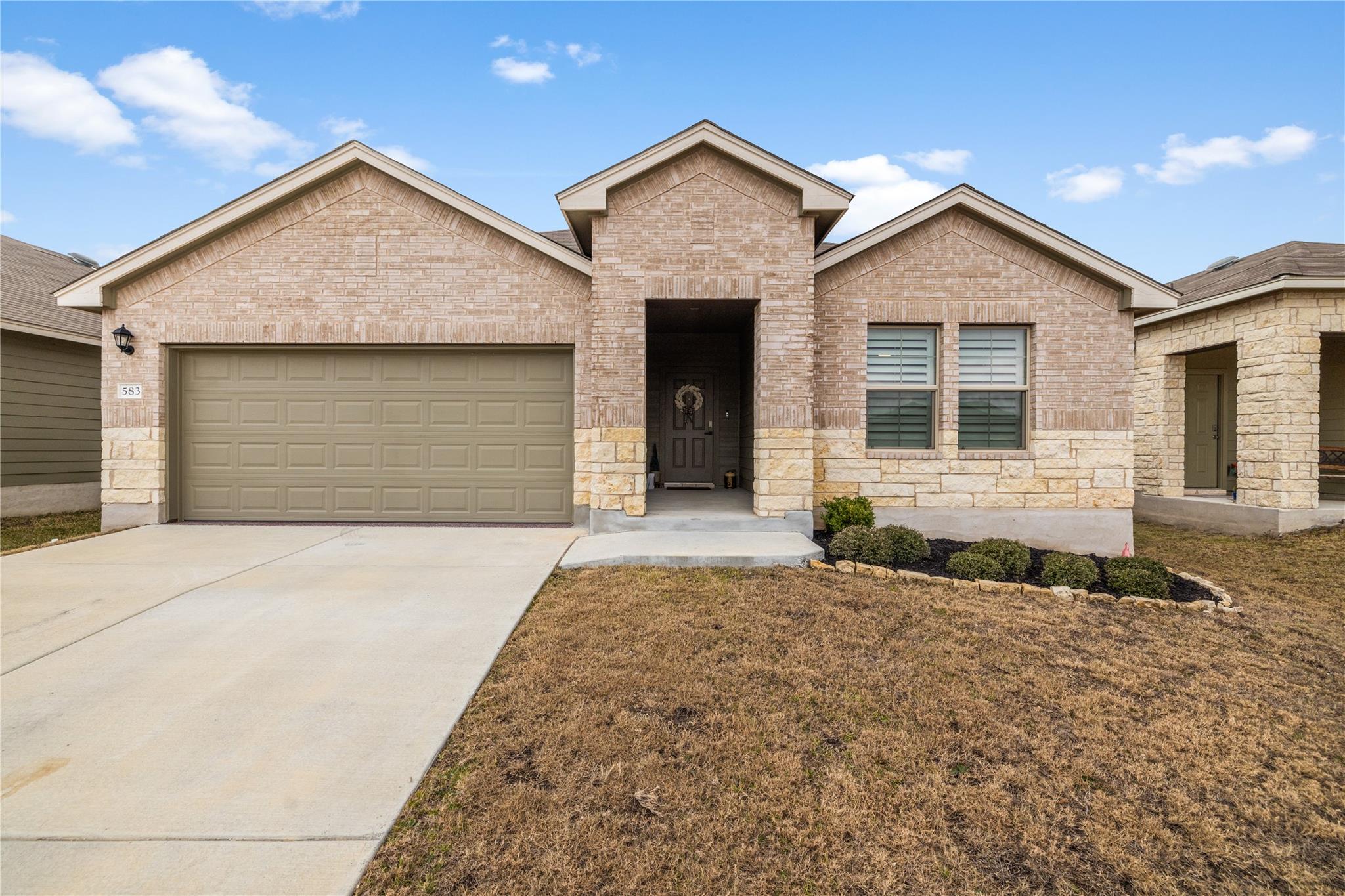 View of front of home with a garage, driveway, br