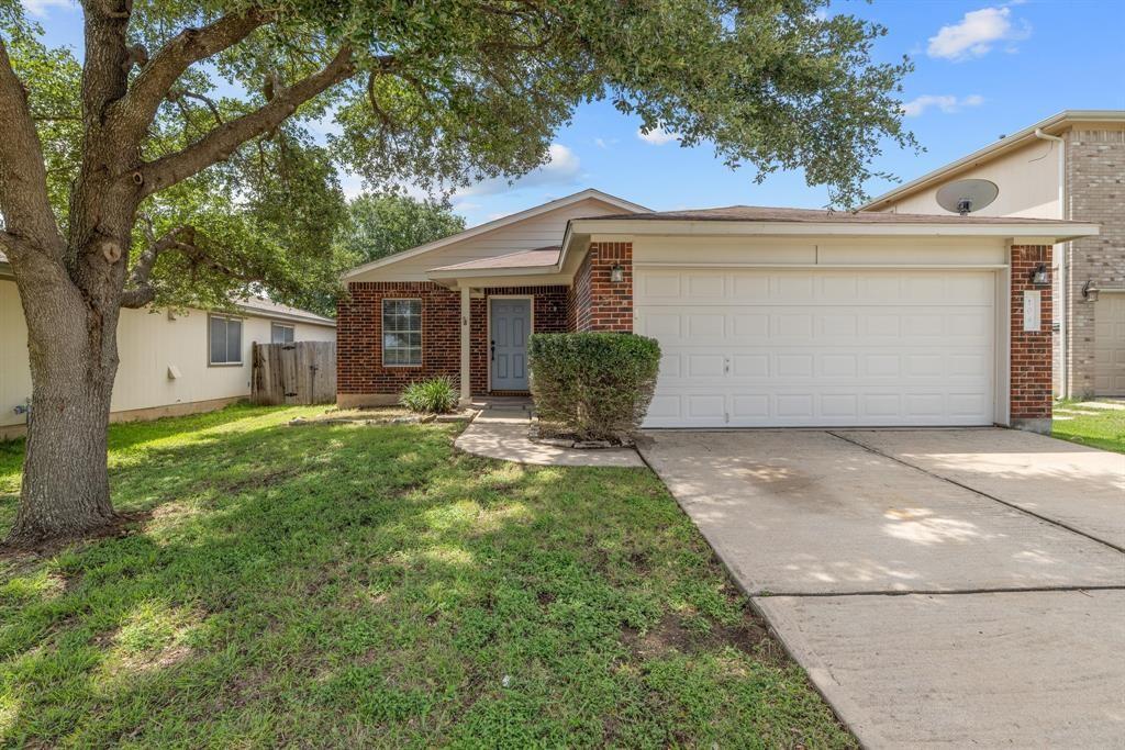 Mature trees shade the concrete driveway and clas