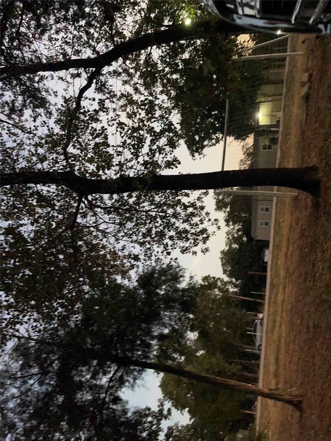 Mature trees frame a spacious grassy property und