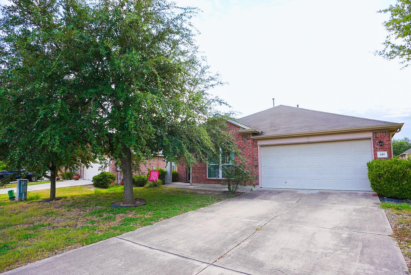 Mature shade trees frame a classic brick exterior