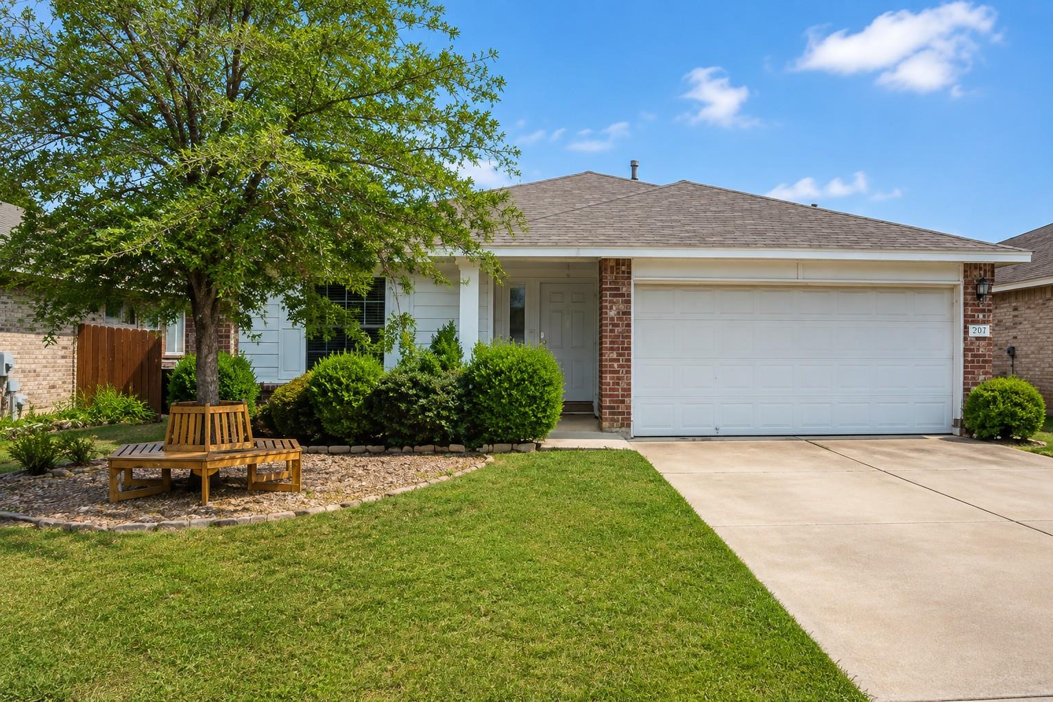 Manicured green lawn and mature shade trees borde