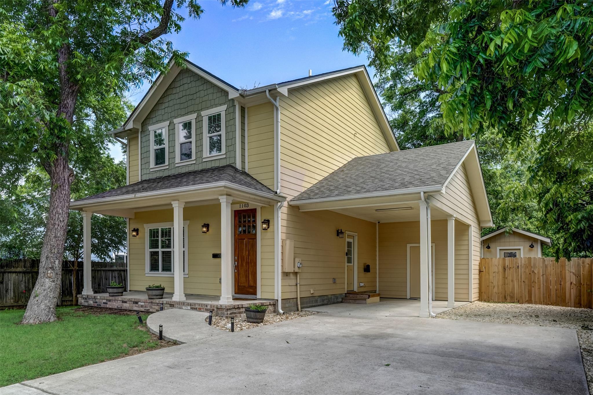 Mature trees shade a welcoming front porch and co