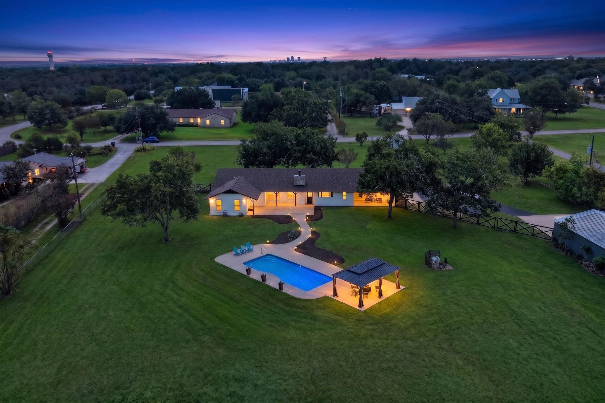 An inviting backyard oasis features a glowing swi