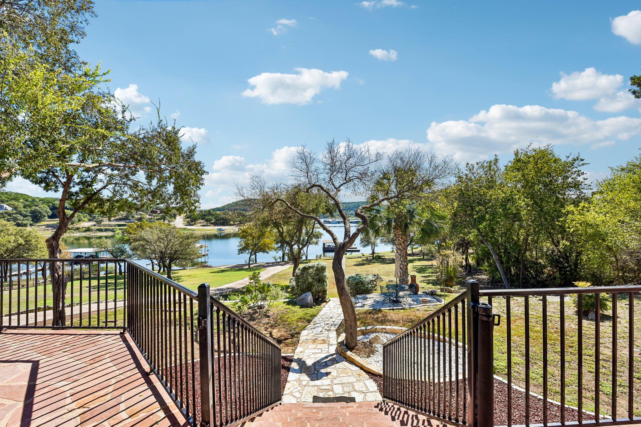 Stone-paved steps lead down to a spacious yard wi