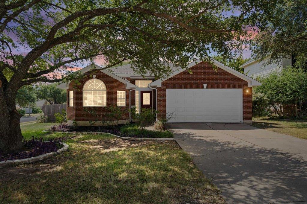 Mature trees shade a classic brick exterior compl