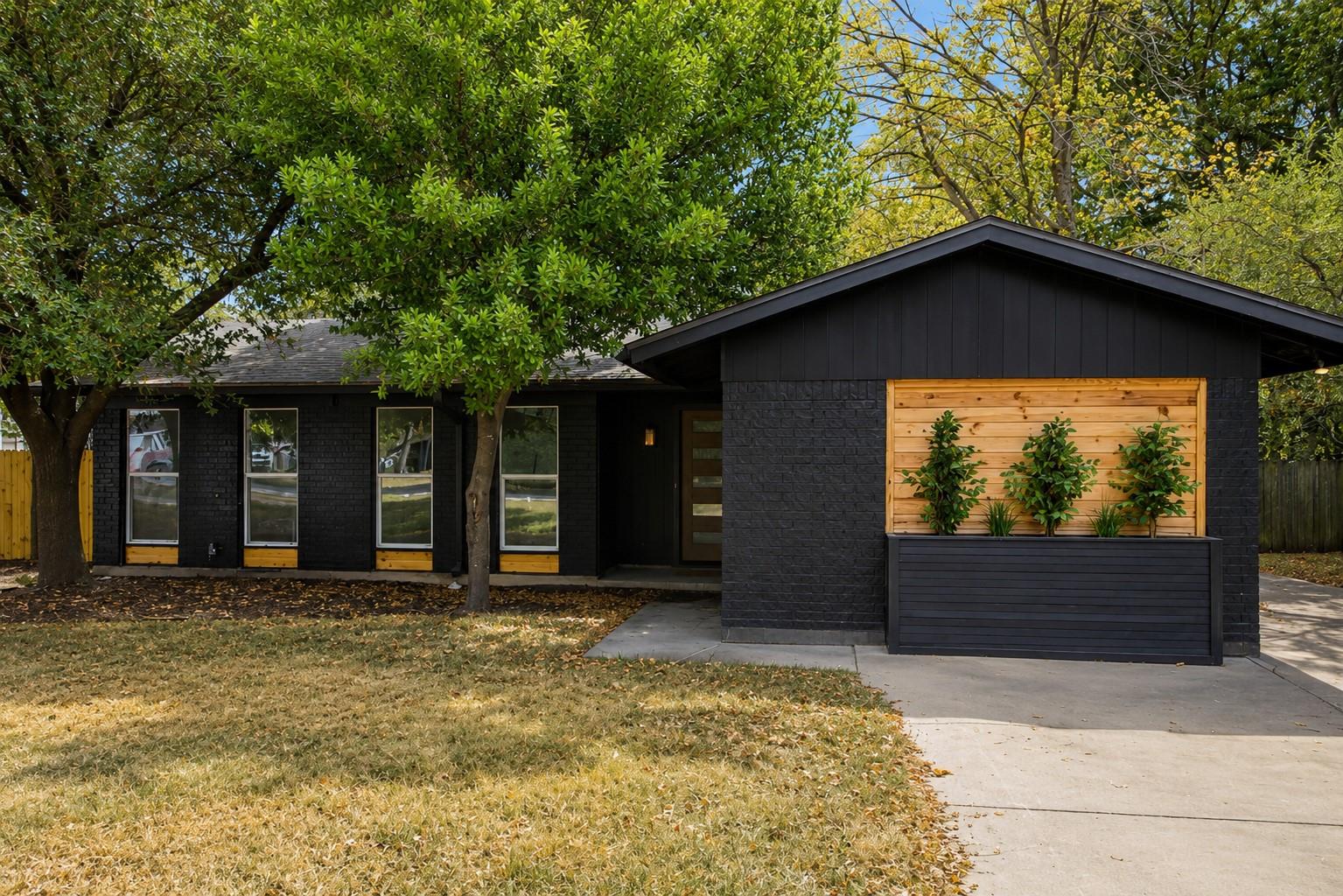 Mature trees shade a contemporary exterior featur