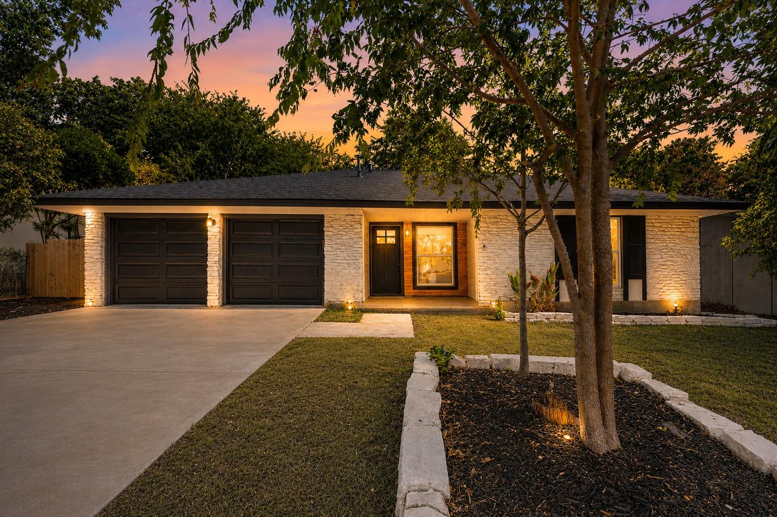 Mature trees frame a welcoming entrance path lead
