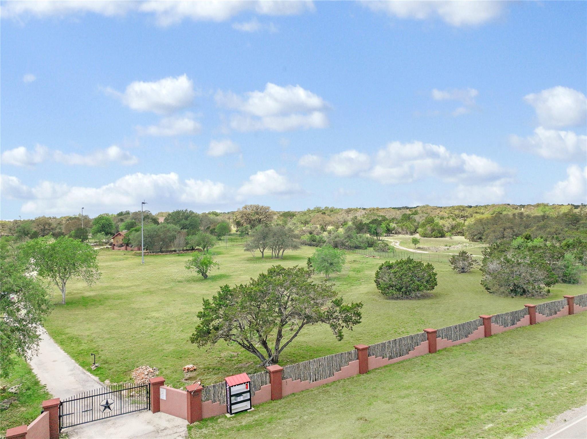 Expansive green acreage unfolds beyond a secure g