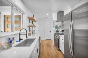 Gleaming stone countertops and warm wood floors d