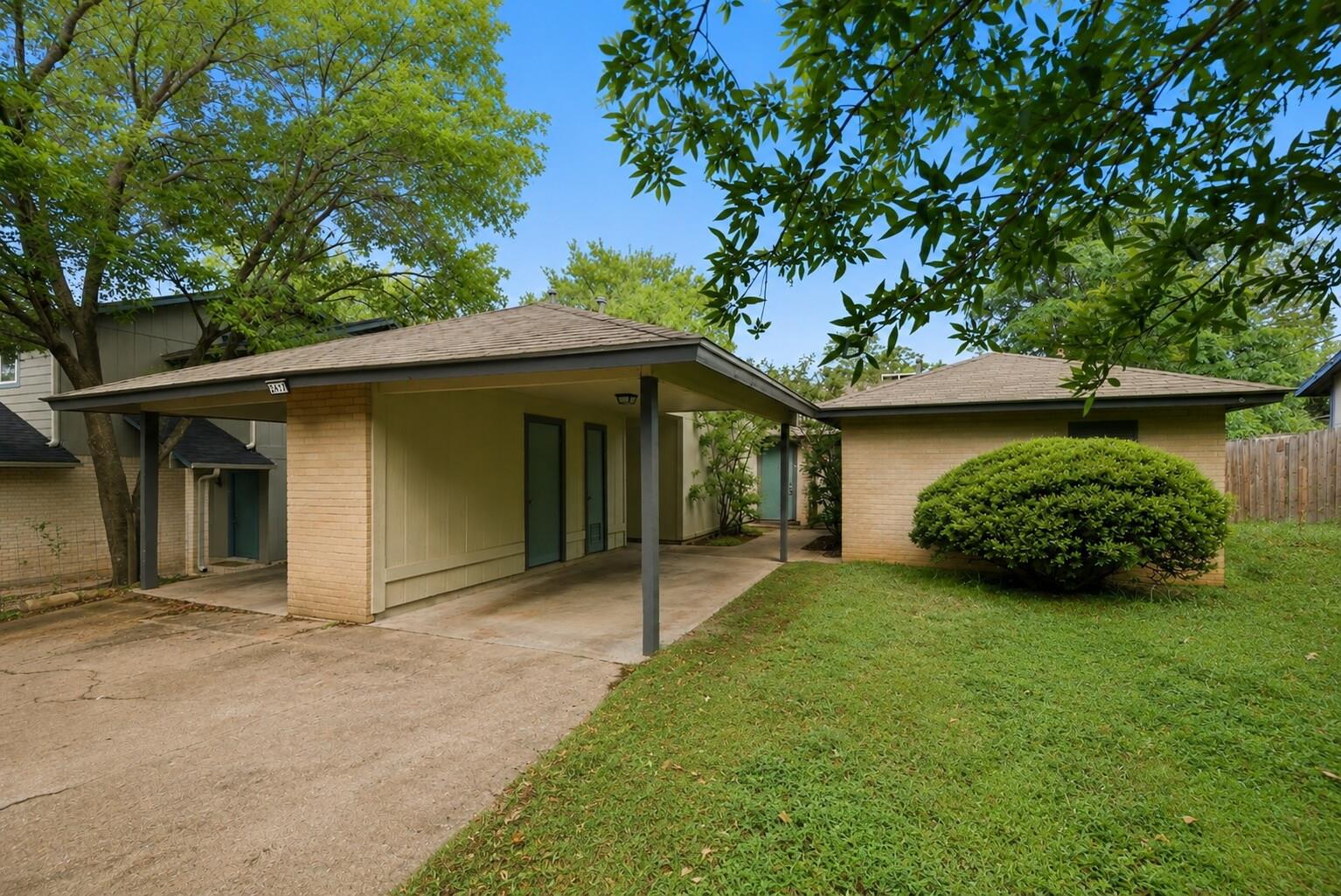 Mature trees frame a classic brick exterior compl