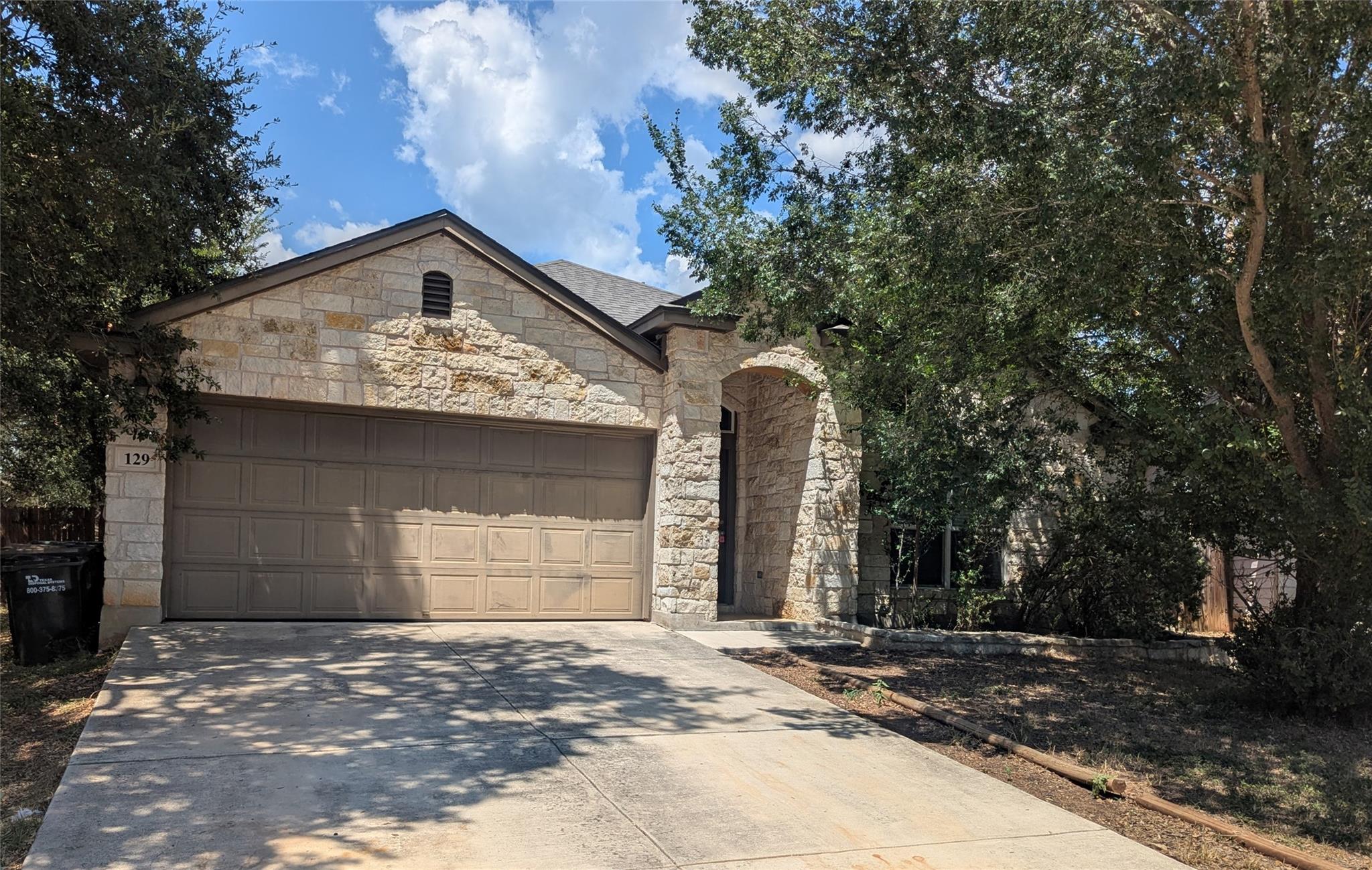 Mature trees shade a classic stone exterior featu