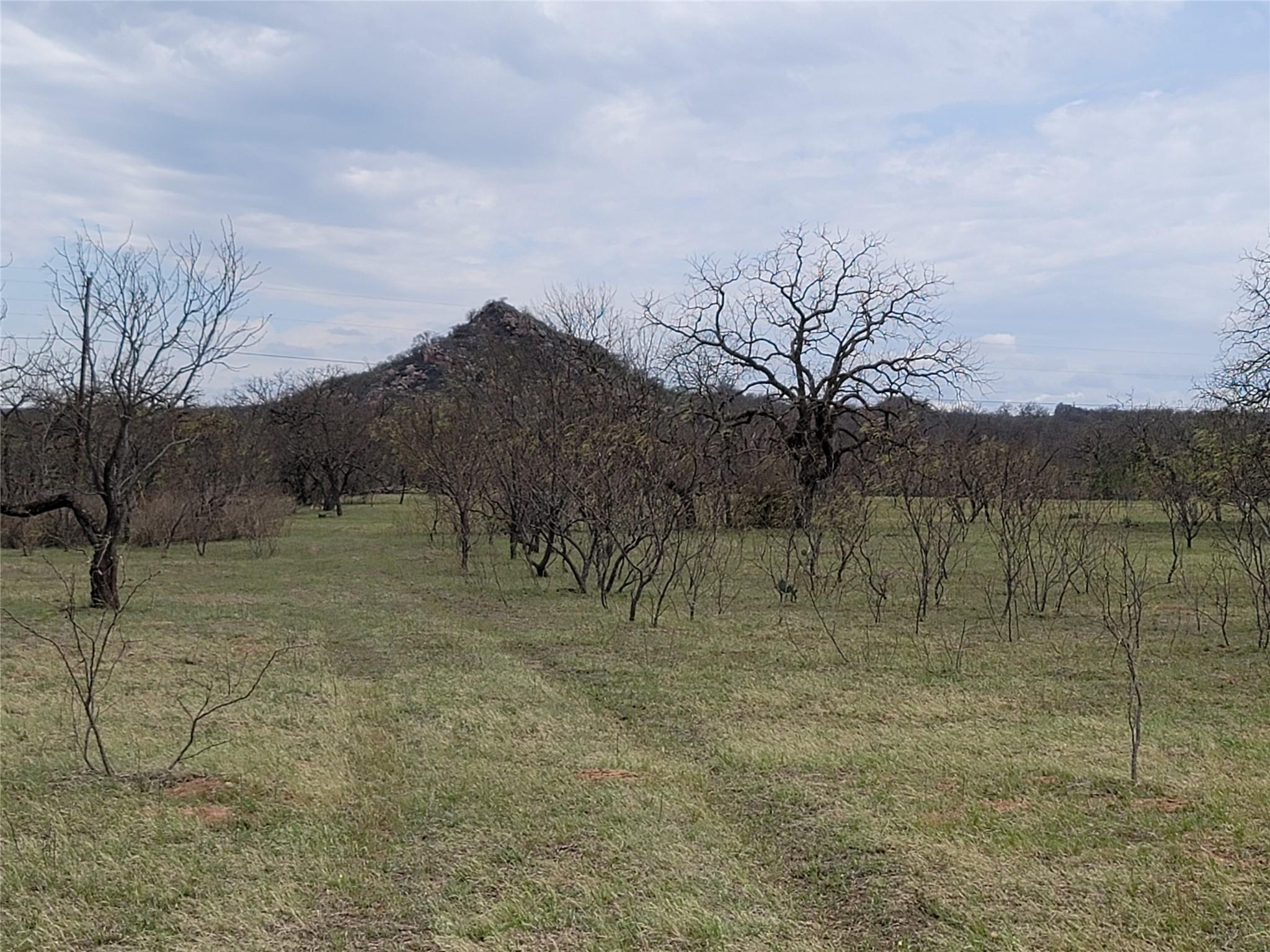 Rolling grassy fields unfold toward a prominent r