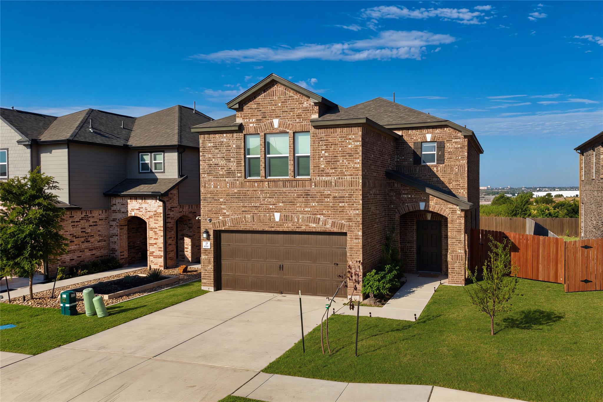 An inviting brick facade and two-car garage creat