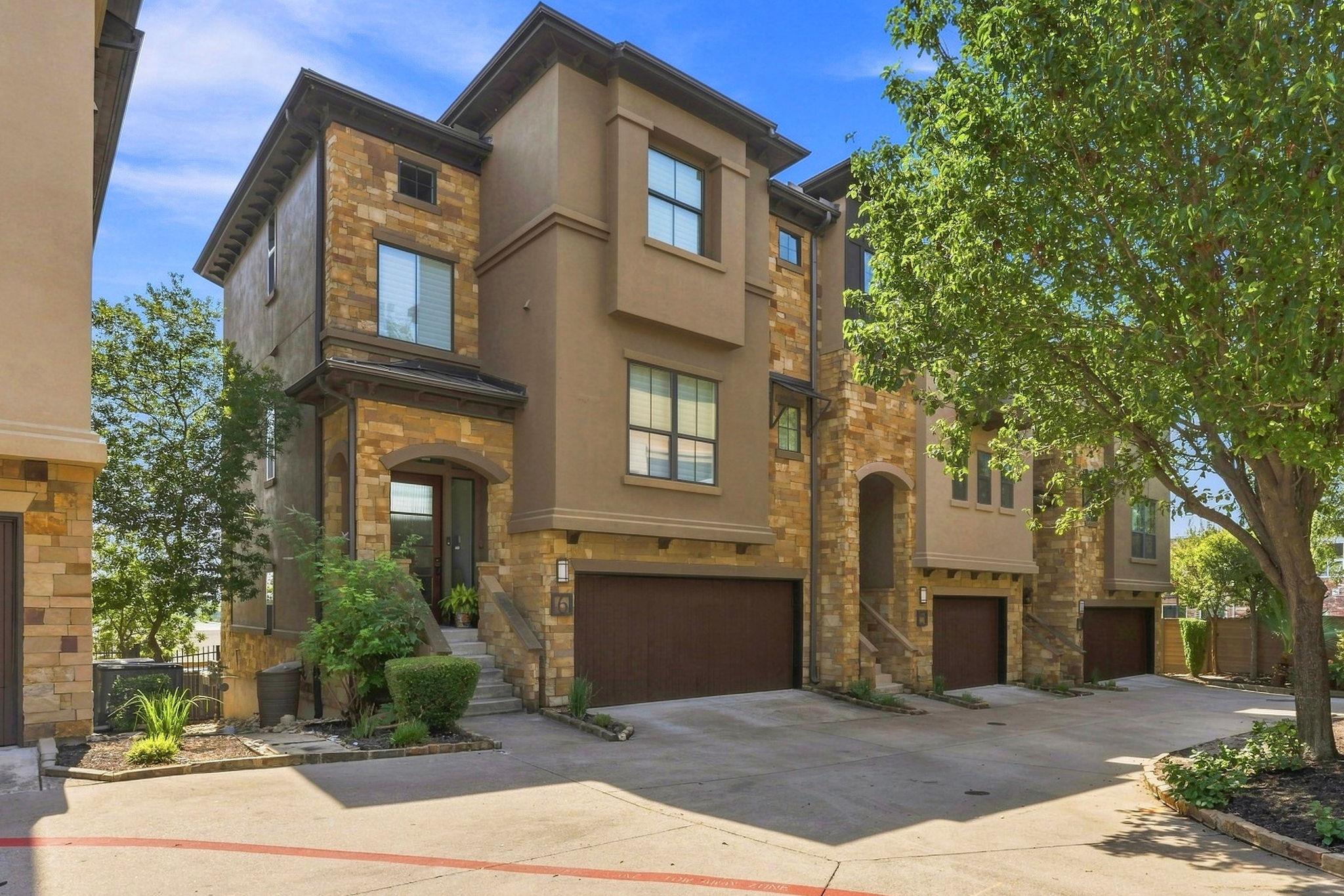 Multi-level stone and stucco townhome features an