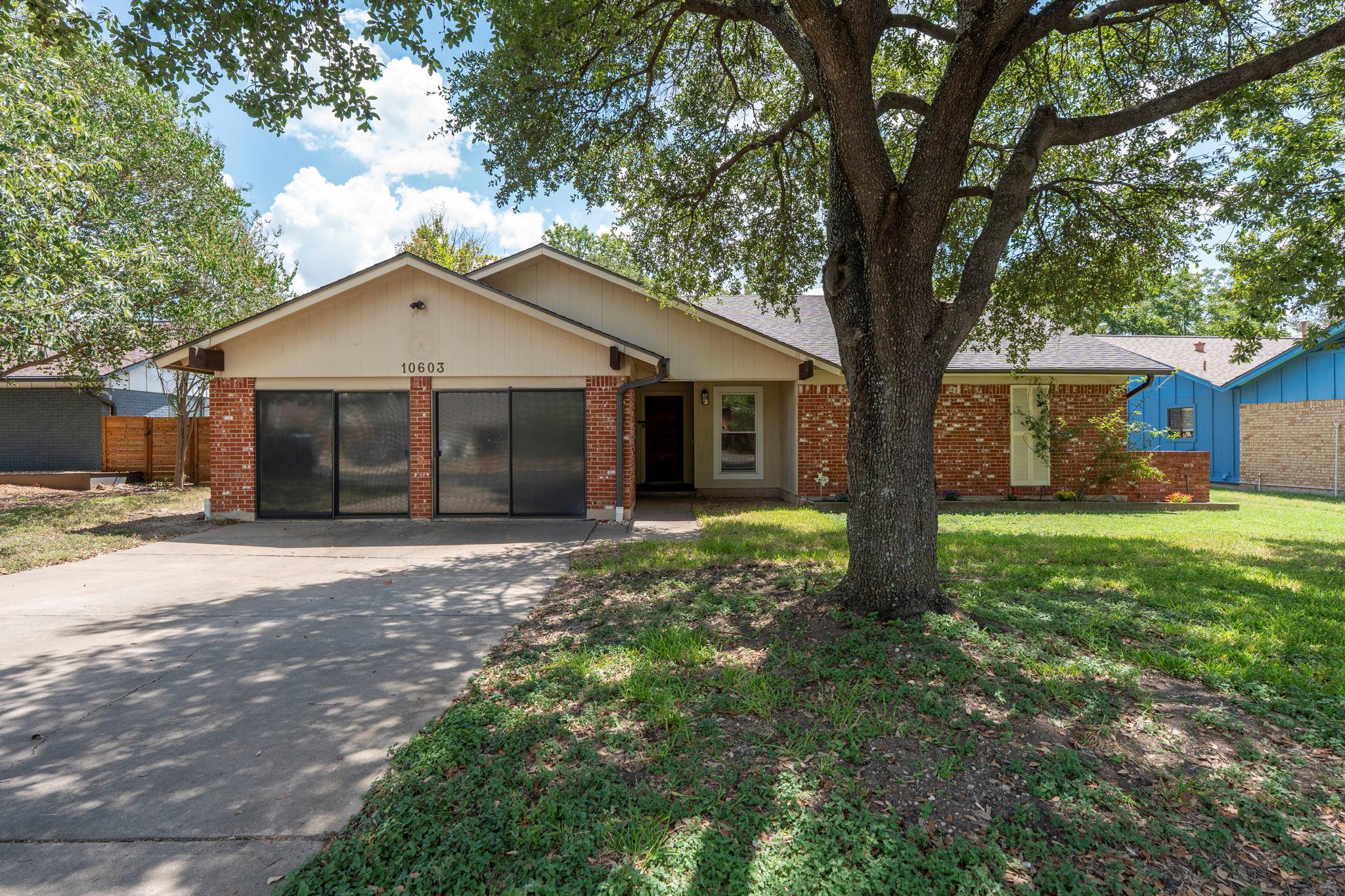 Mature shade trees frame a classic single-story b