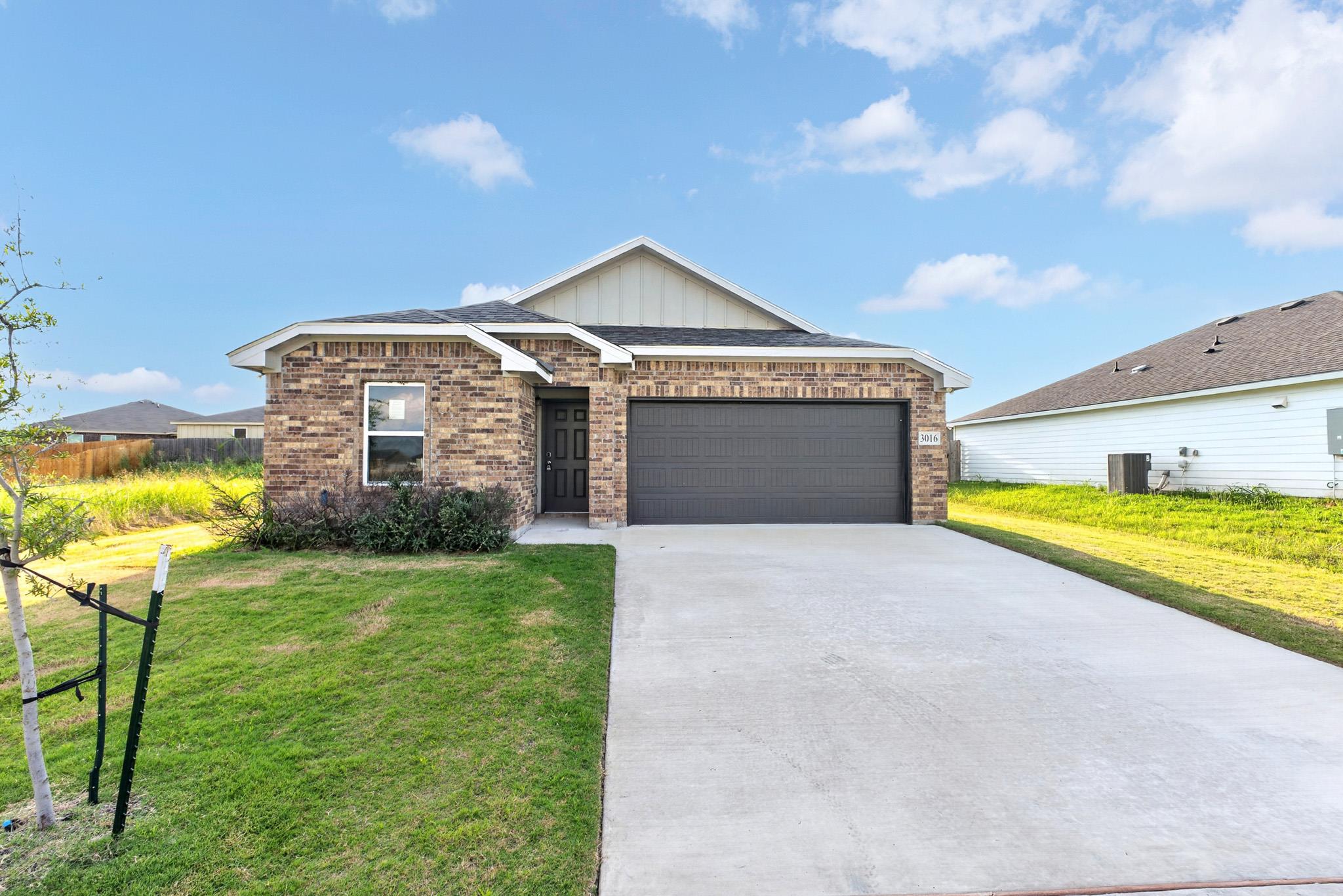 Brick accents and a spacious concrete driveway de