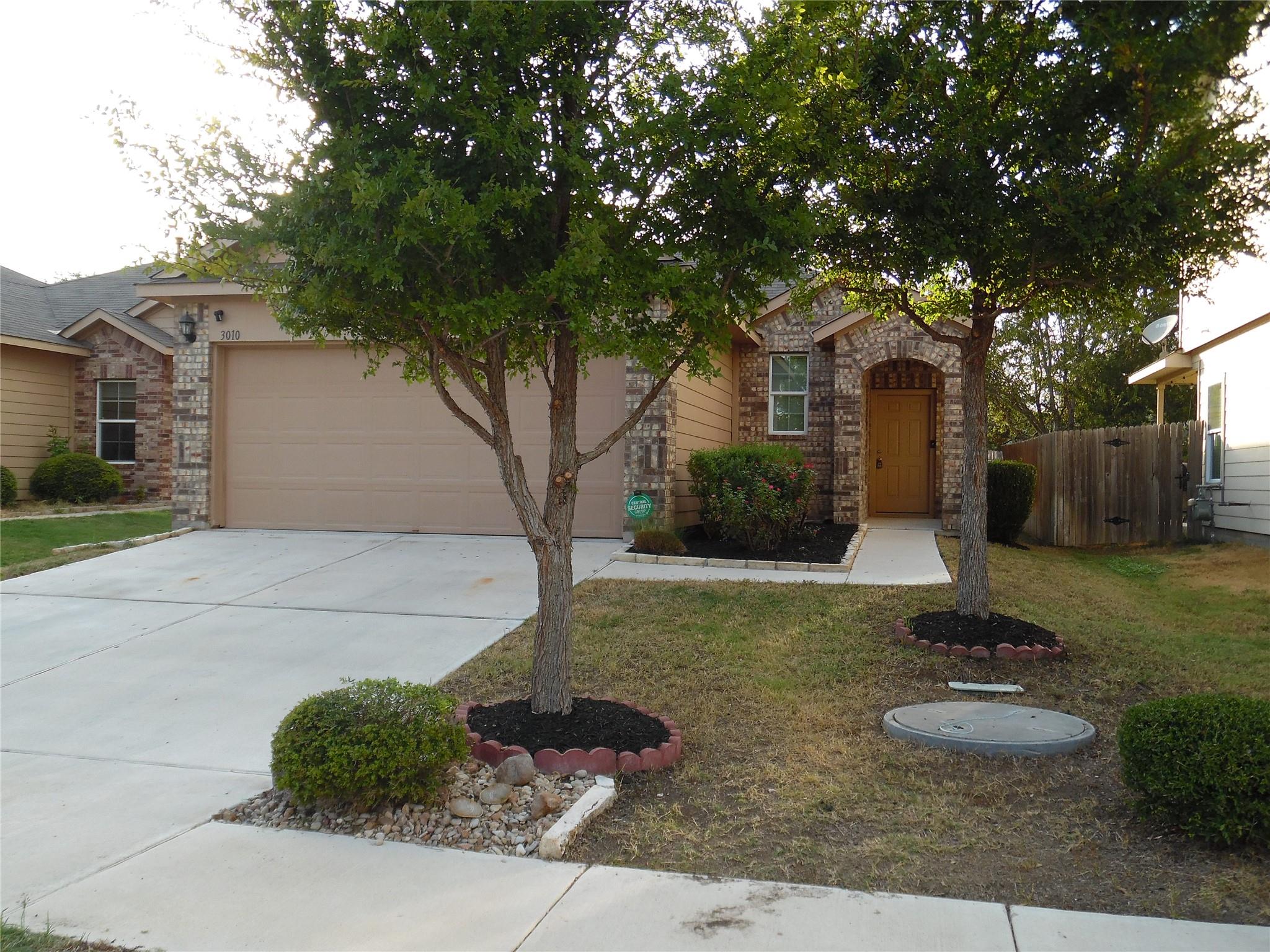 A classic brick exterior and concrete driveway de