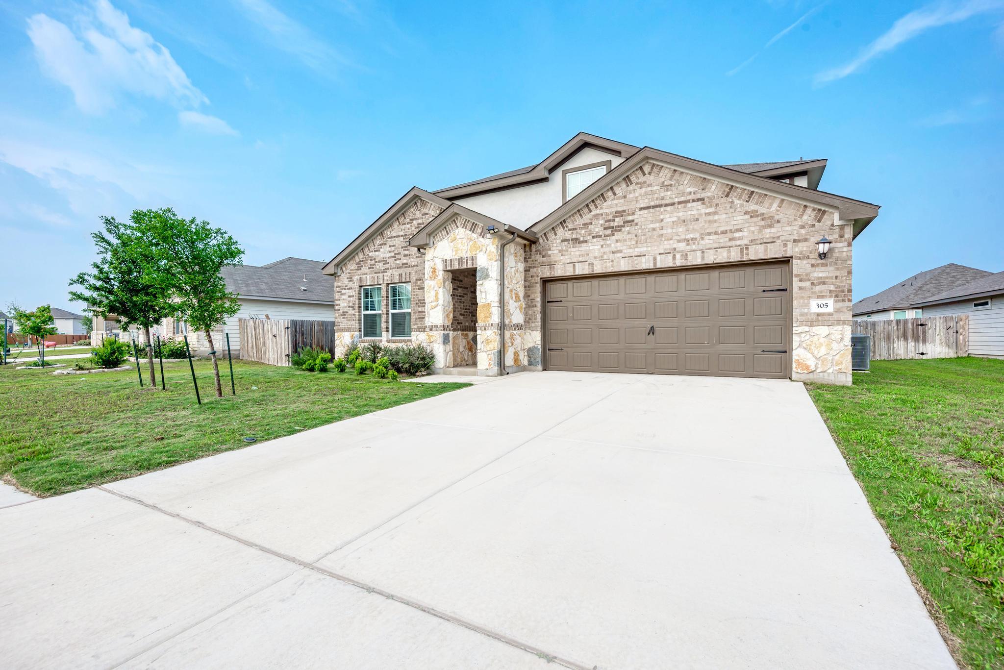 A wide concrete driveway leads directly to the in