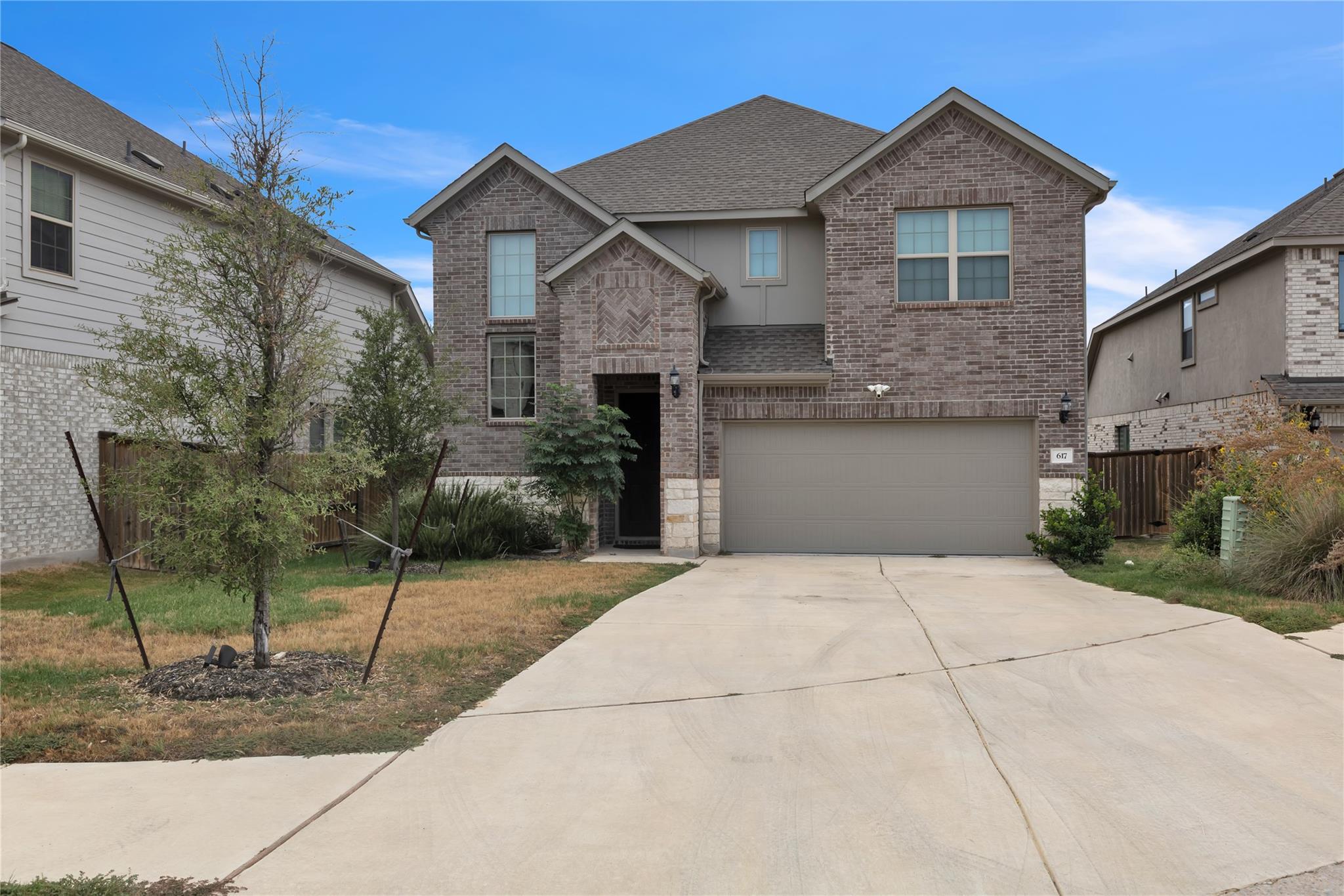 A spacious concrete driveway leads to the two-sto