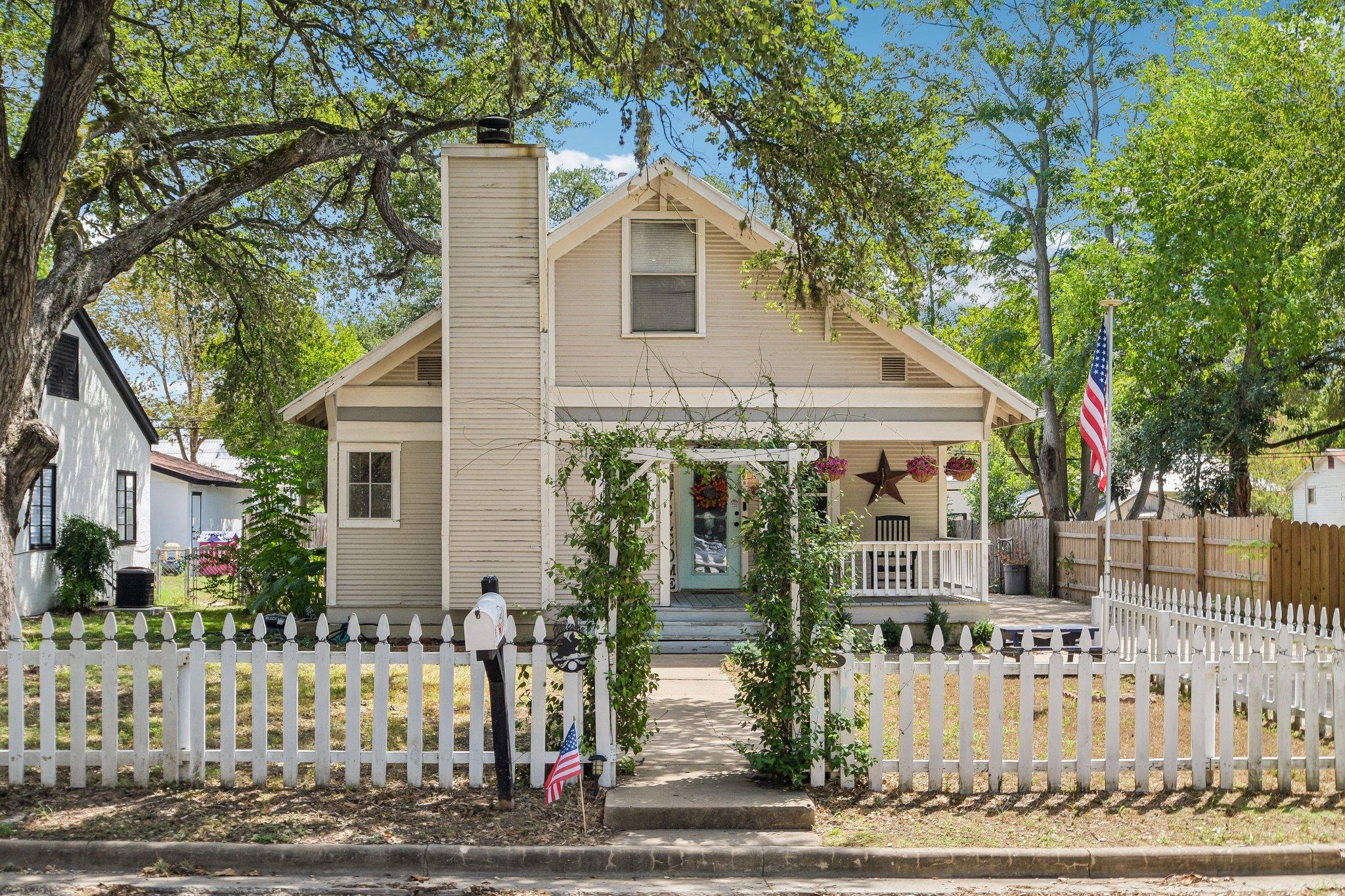 Mature trees frame this classic cottage featuring