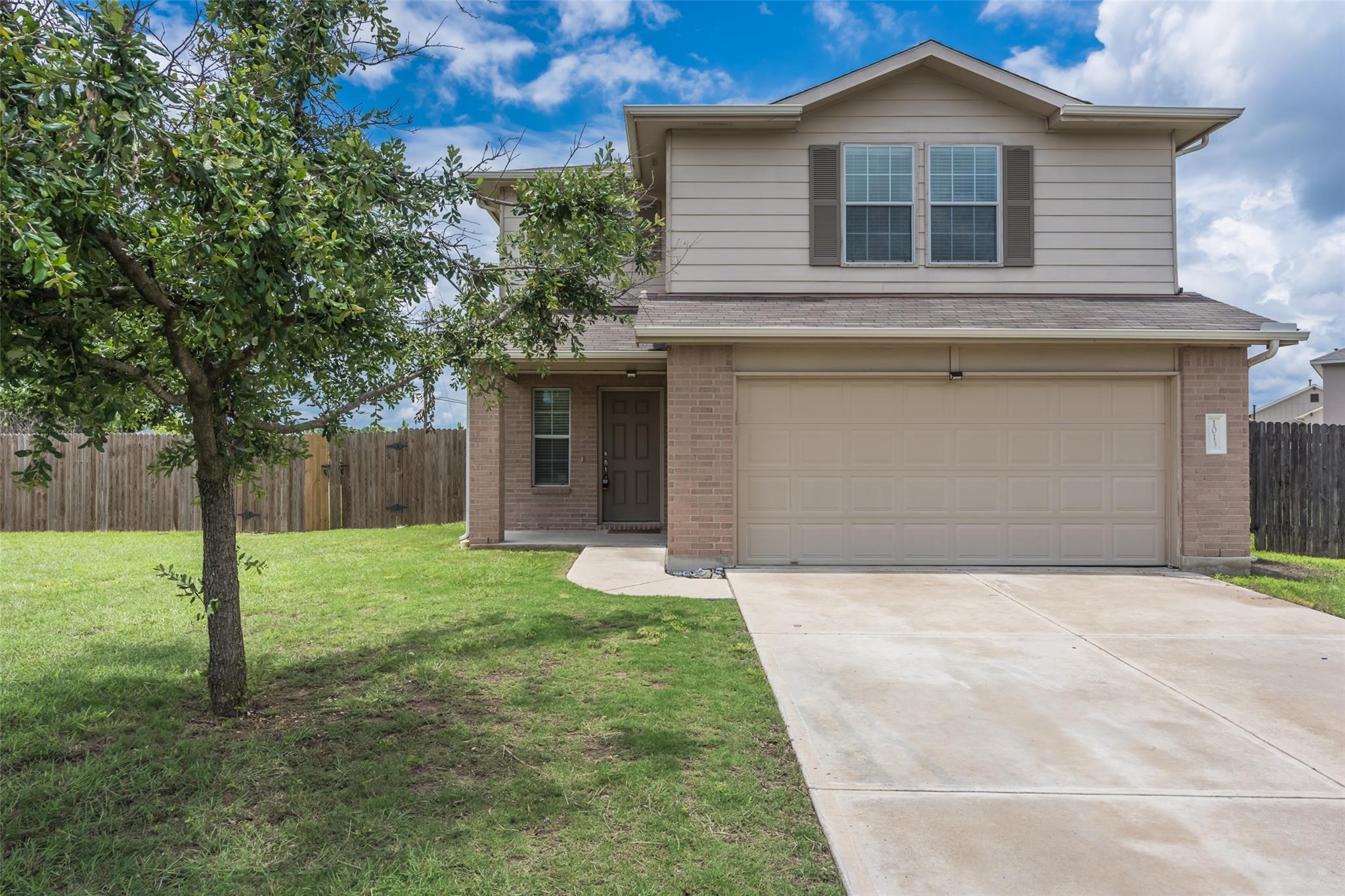 A classic brick and siding exterior features a sp