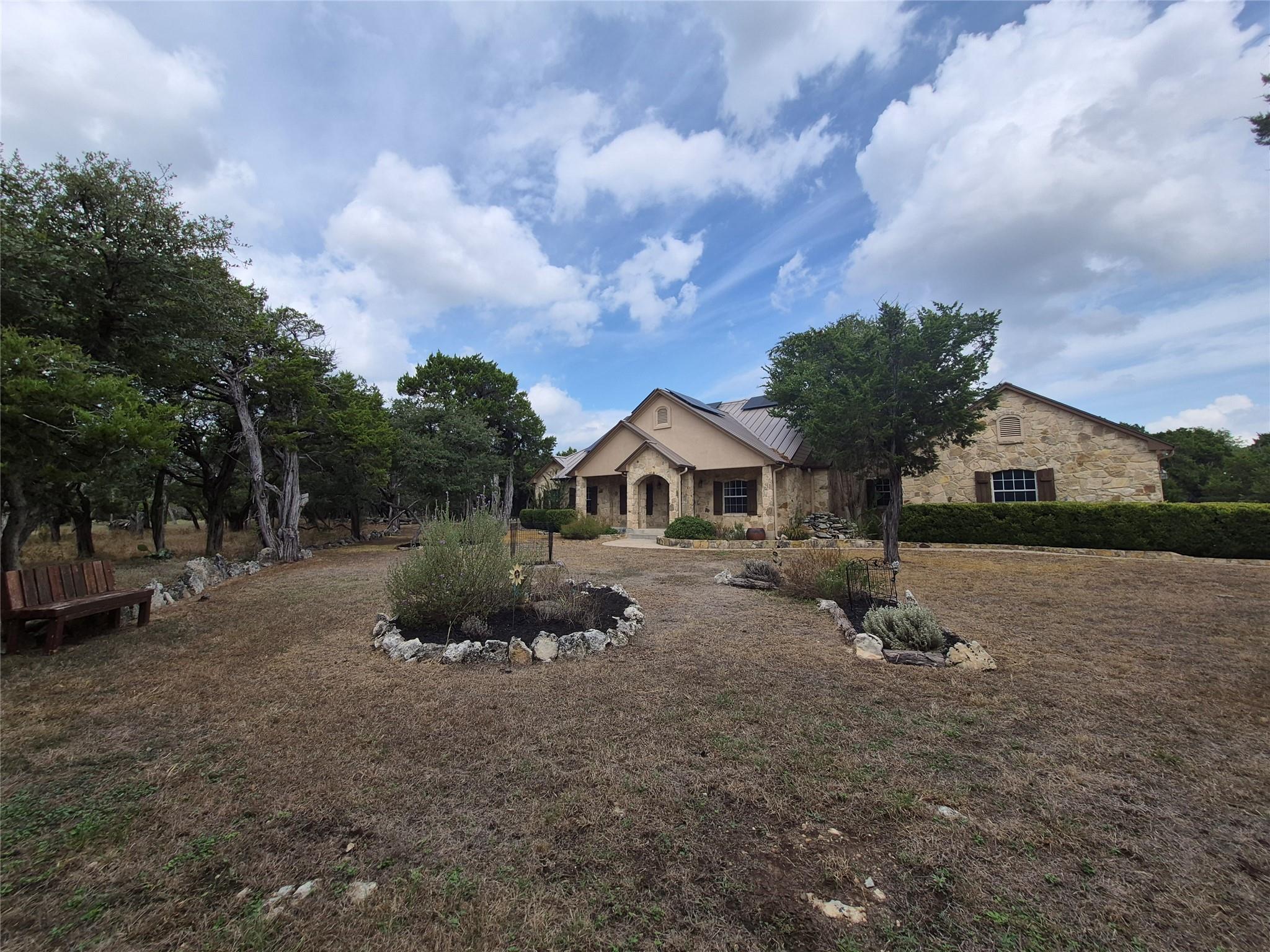 Mature trees frame a classic stone exterior with 