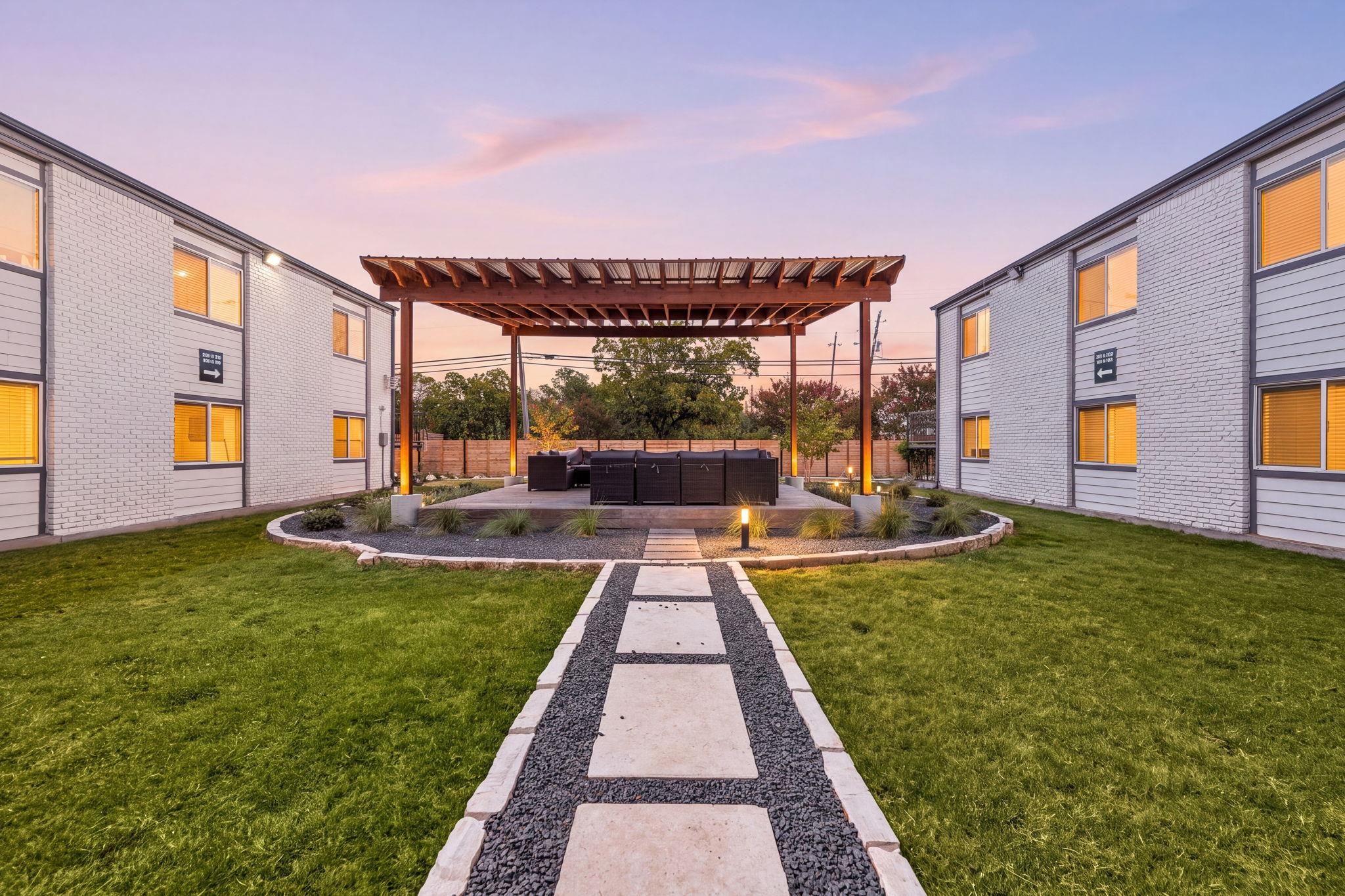 A stone pathway leads through a grassy courtyard 