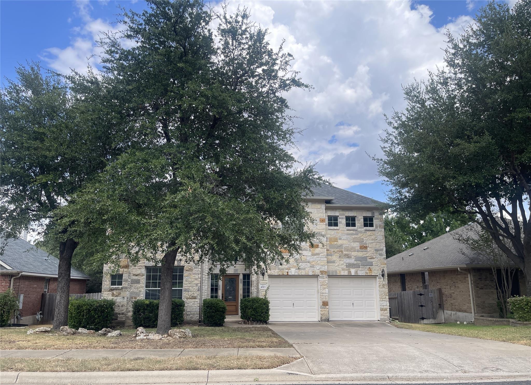 Mature trees shade a classic stone exterior with 