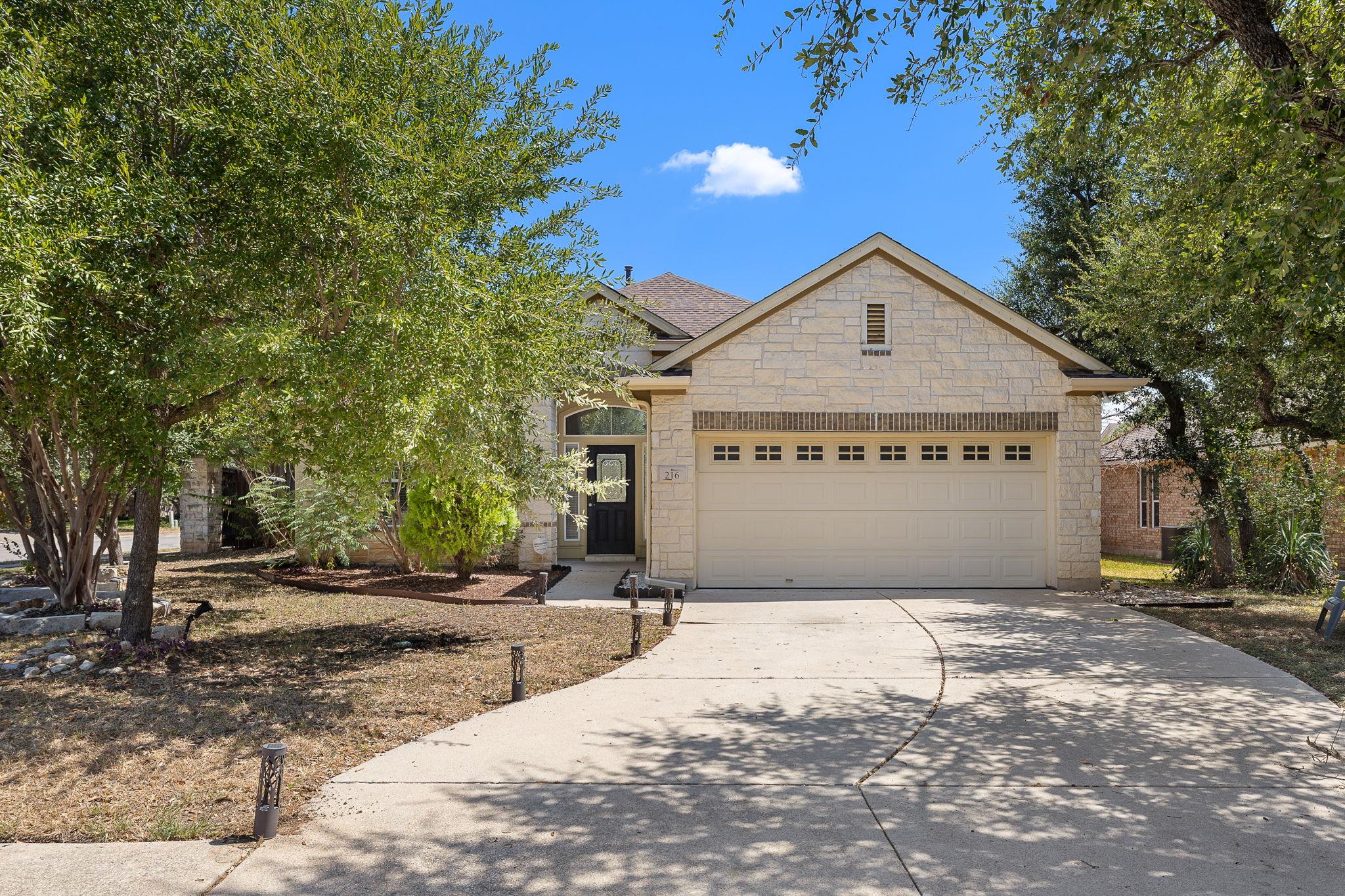 Mature trees frame a classic stone exterior with 