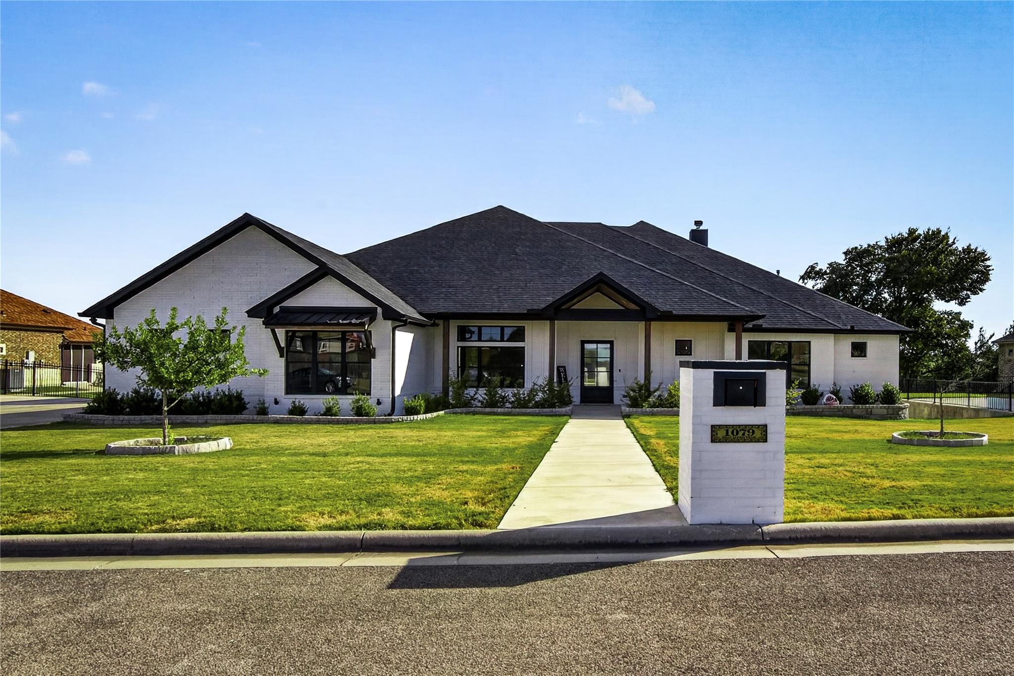 A concrete walkway leads to the covered front ent