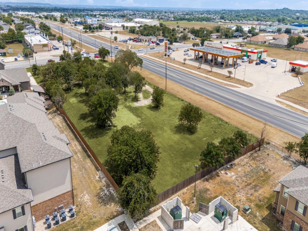 A spacious green lot bounded by fencing offers am