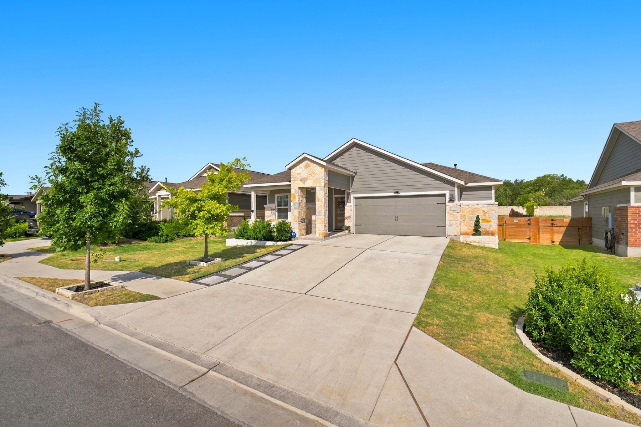 A stone-accented entry and wide concrete driveway