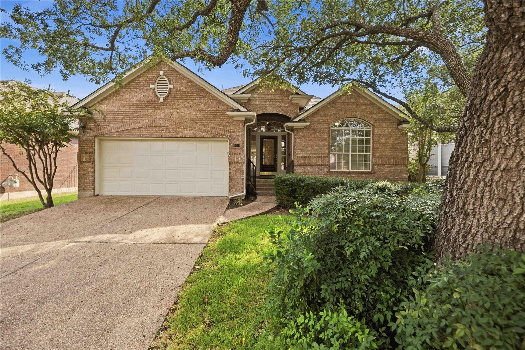 Mature trees shade the classic brick exterior of 