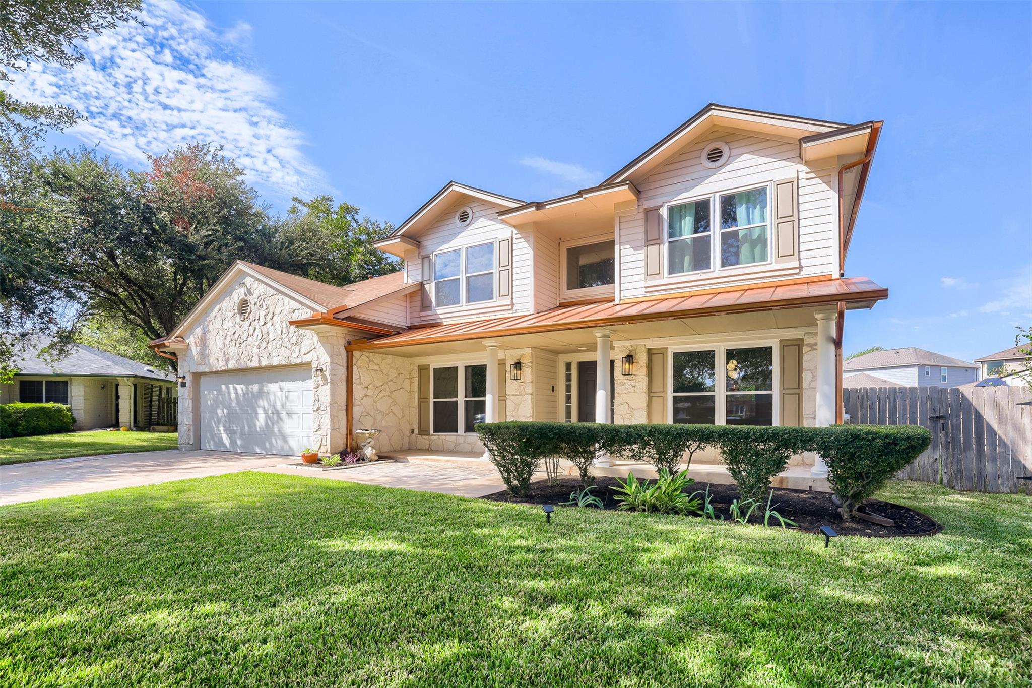 An inviting front facade features native stone ac