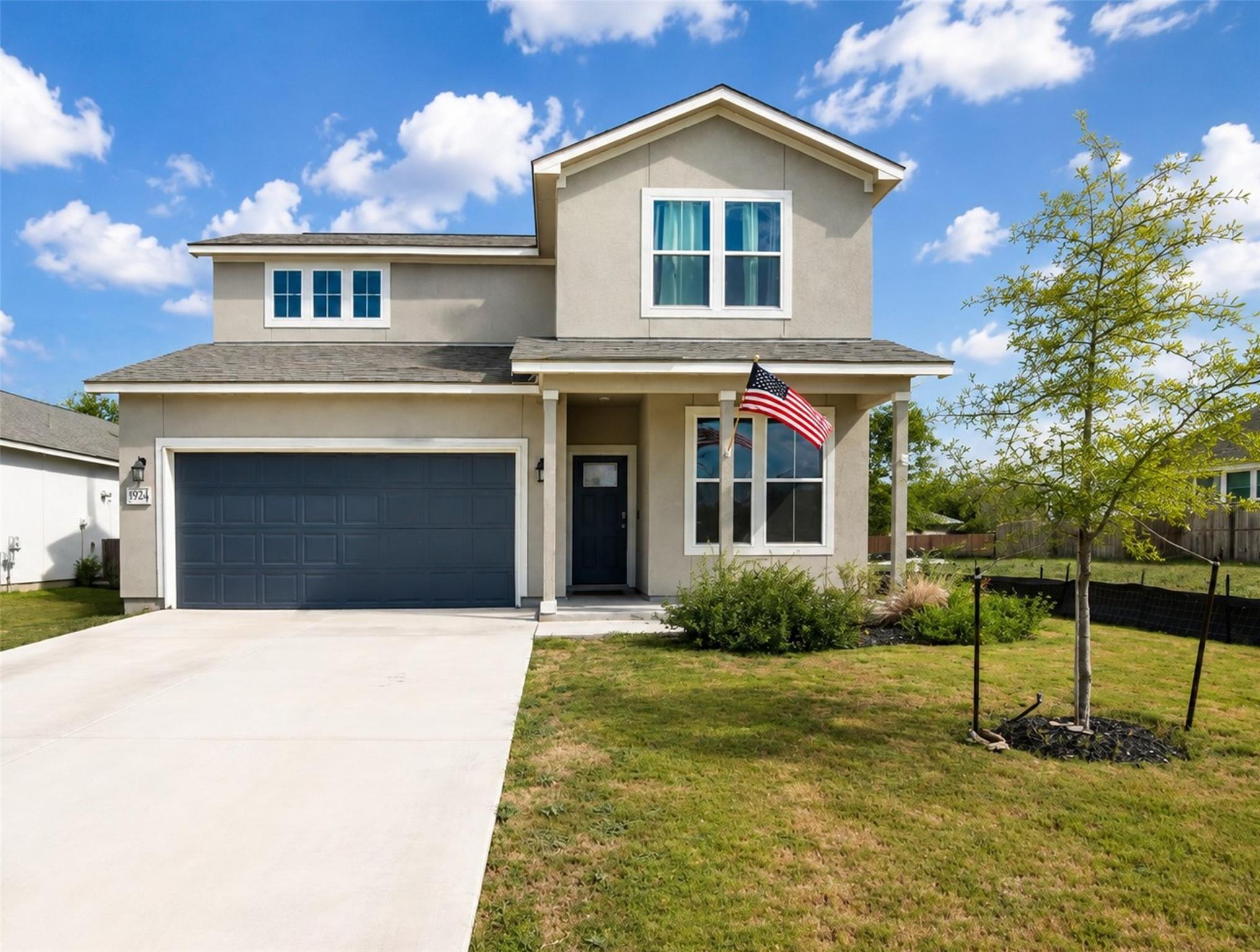 An inviting front porch and a wide concrete drive