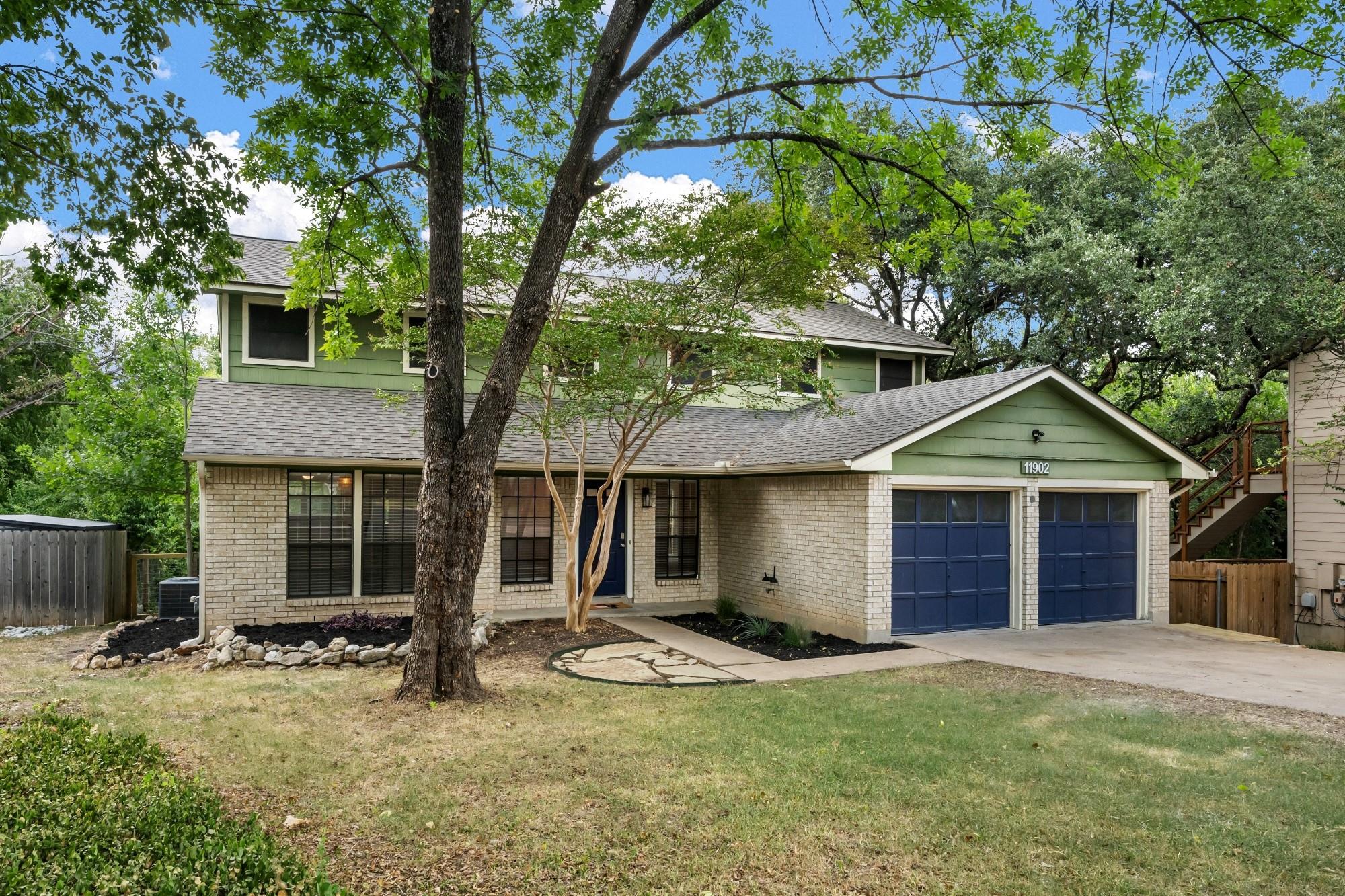 Mature trees frame a classic two-story exterior b