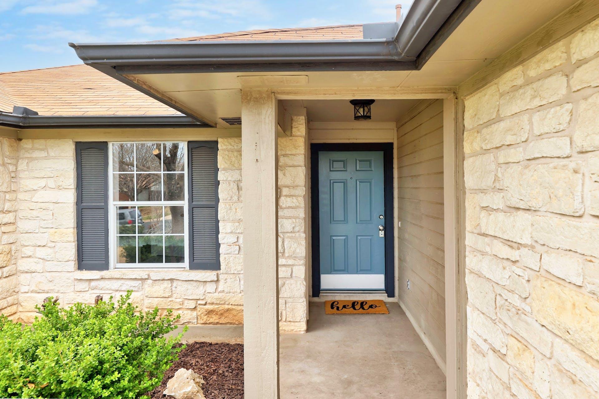 Natural stone masonry frames a welcoming covered 