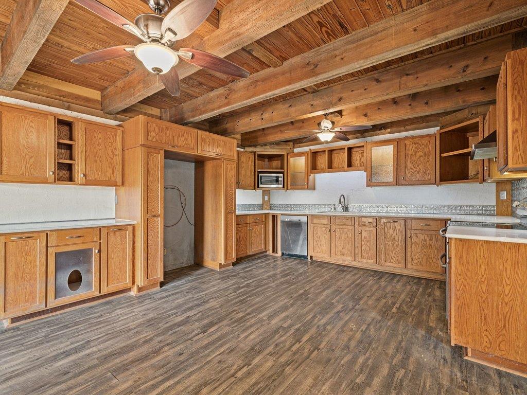 Rich wood plank flooring pairs with heavy beamed 