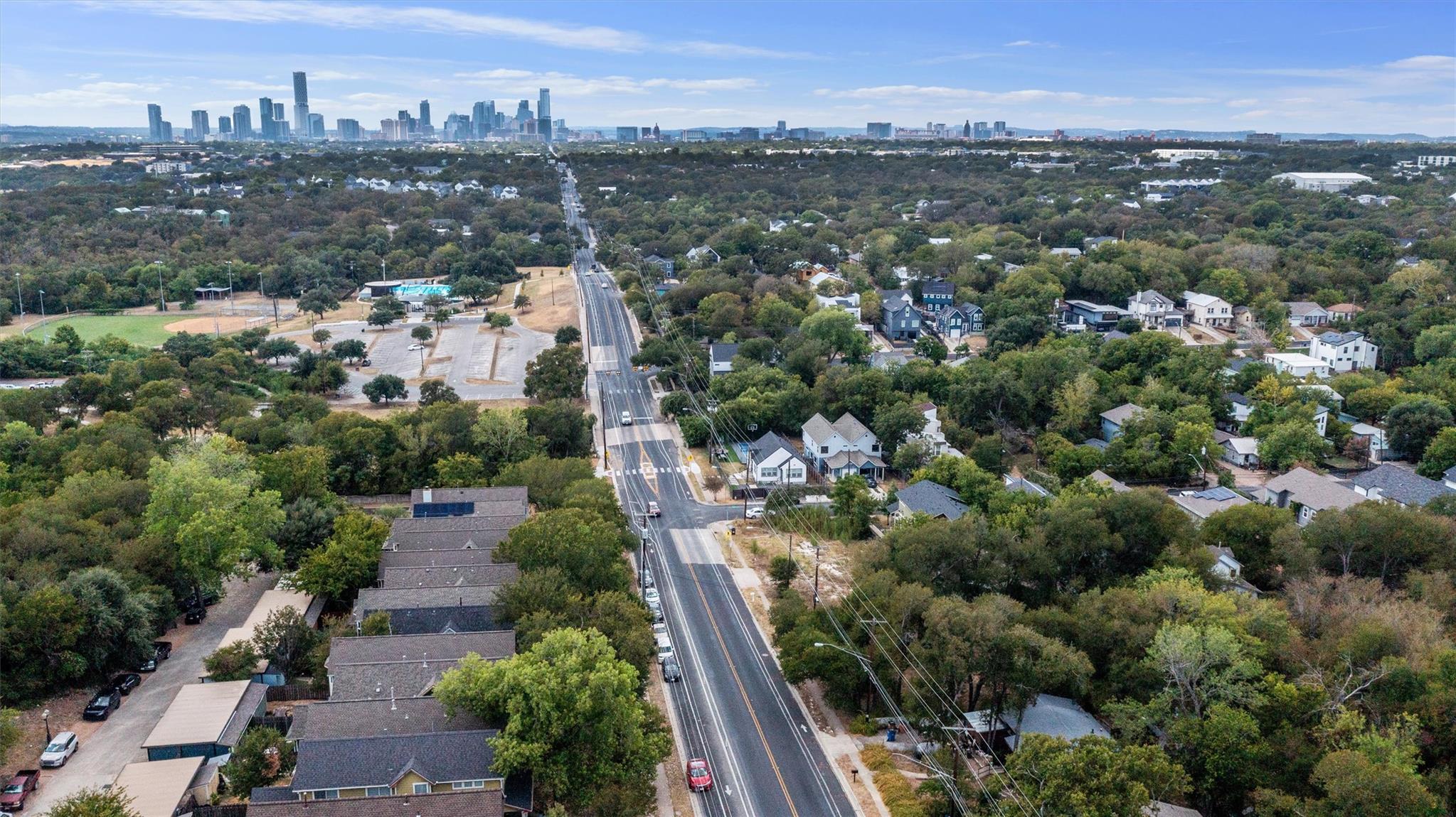 Mature trees frame a sprawling neighborhood persp