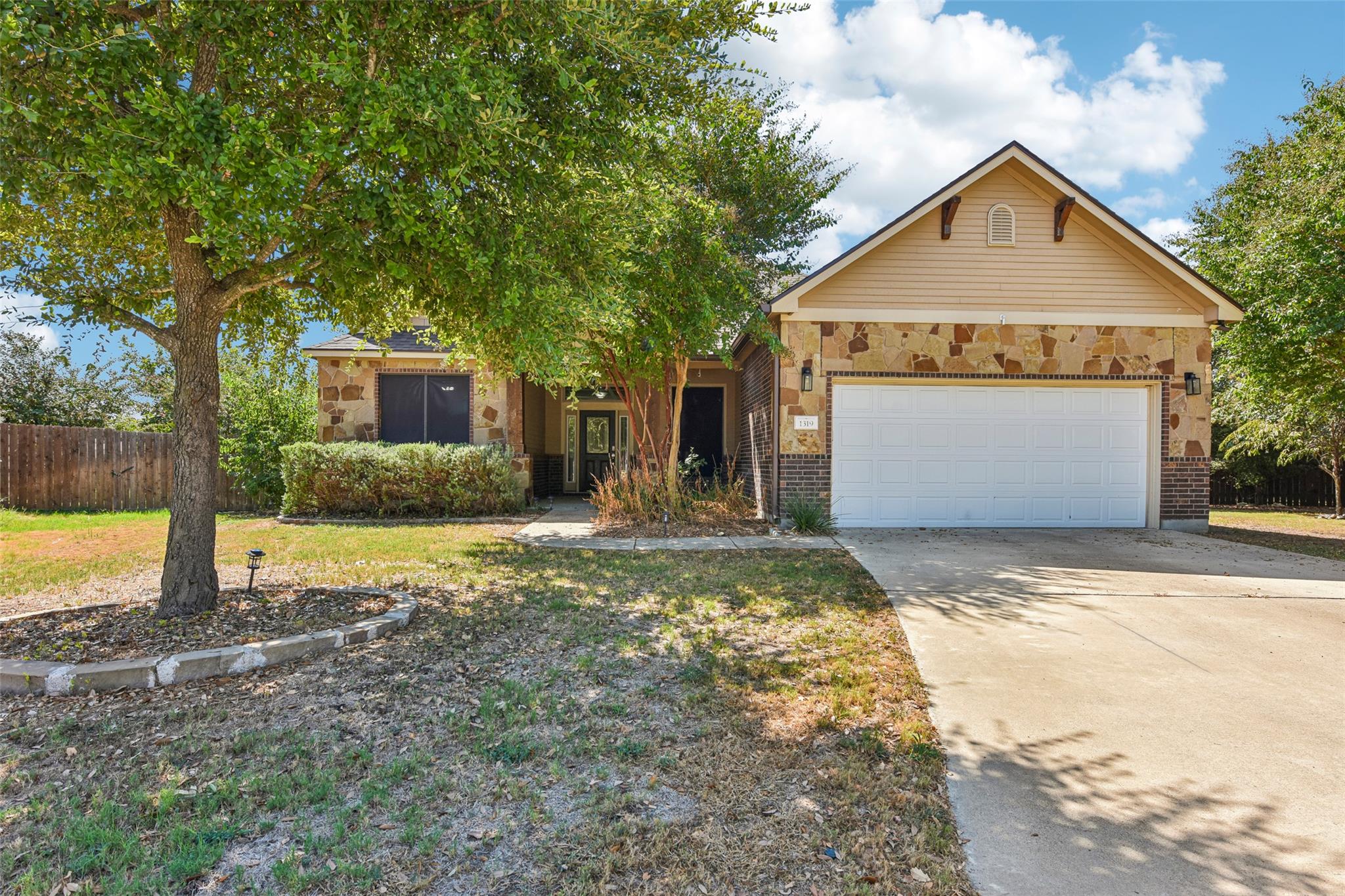 Mature trees frame this charming single-story res