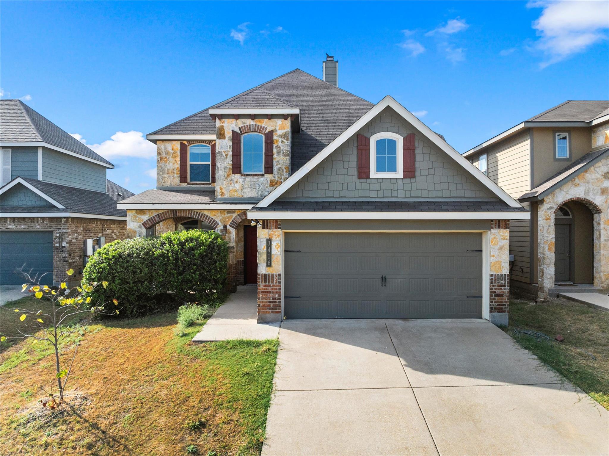 A classic two-story stone elevation with a promin